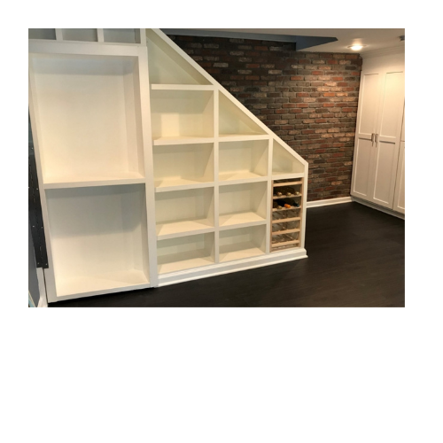 A room with a staircase and a wine rack underneath it.