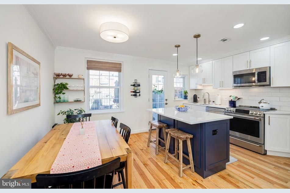 A kitchen with a wooden table and chairs and a large island.