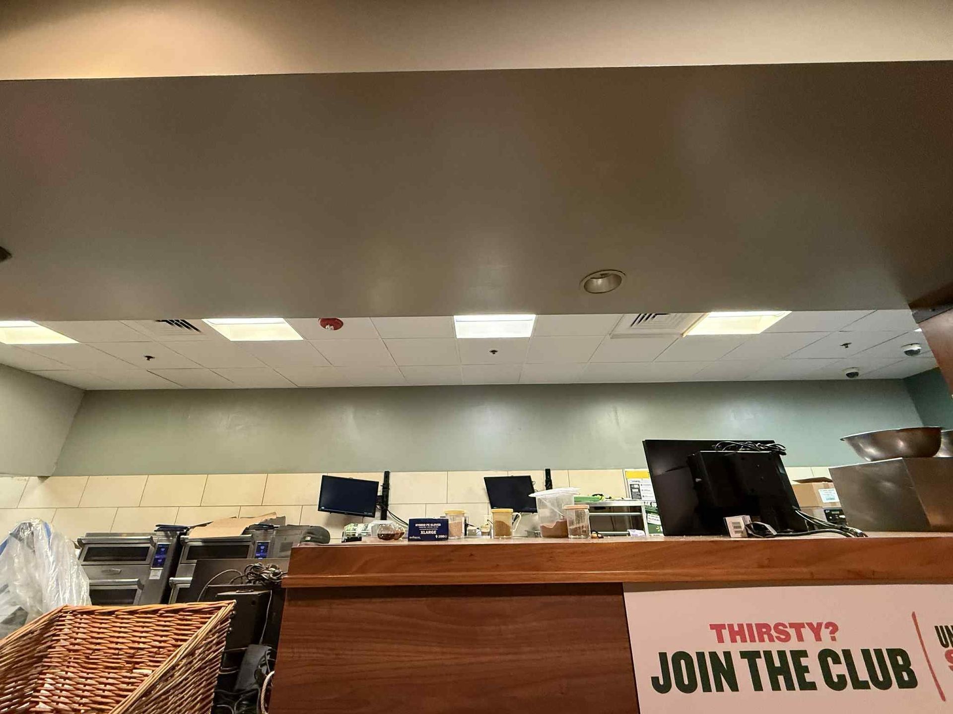 Counter with equipment, display, and a basket in a store. The sign says