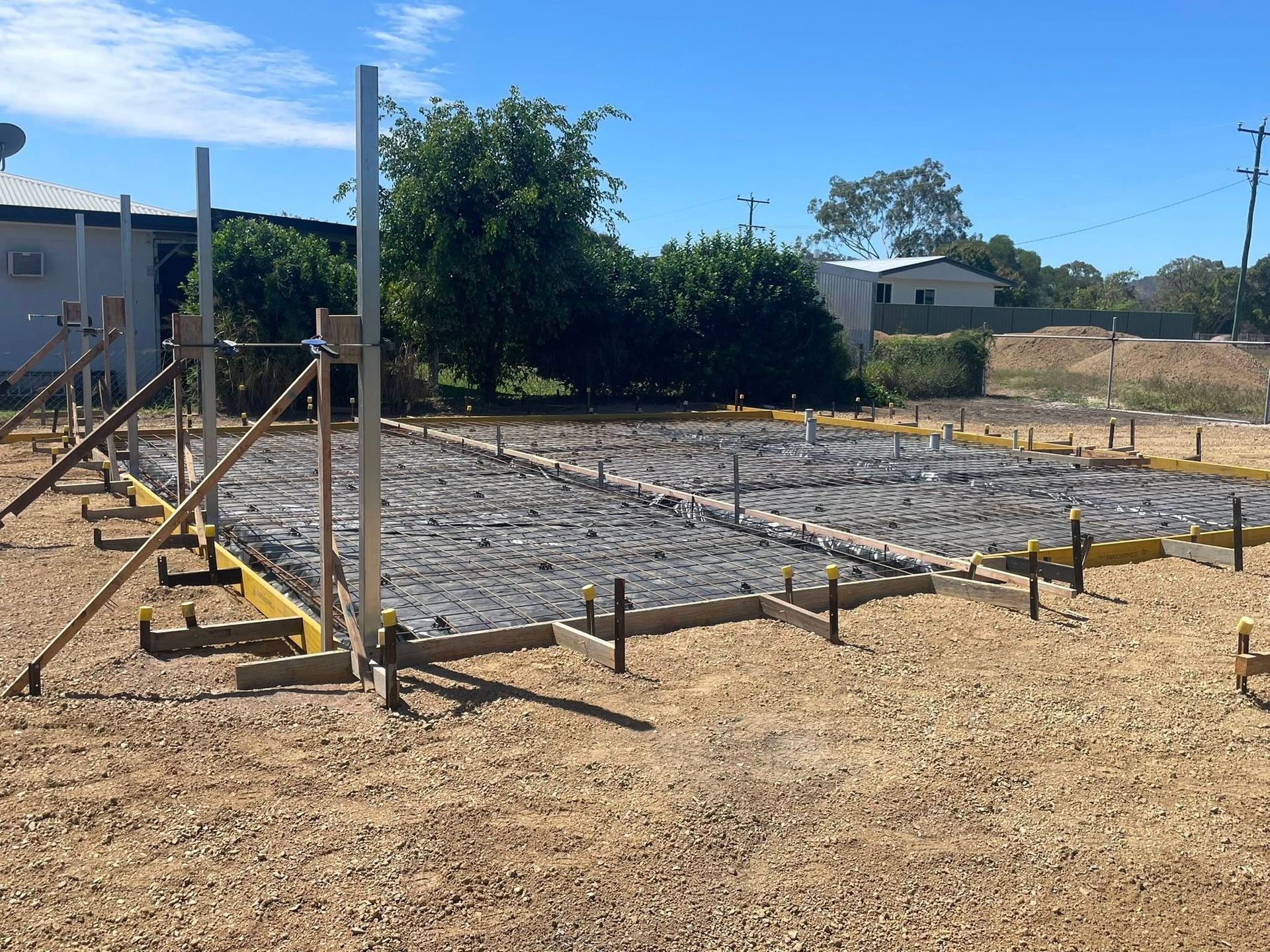 Construction Site With Wooden Forms and Gray Concrete, Sunny Day — Sun Co Concrete And Construction in Dimbulah, QLD