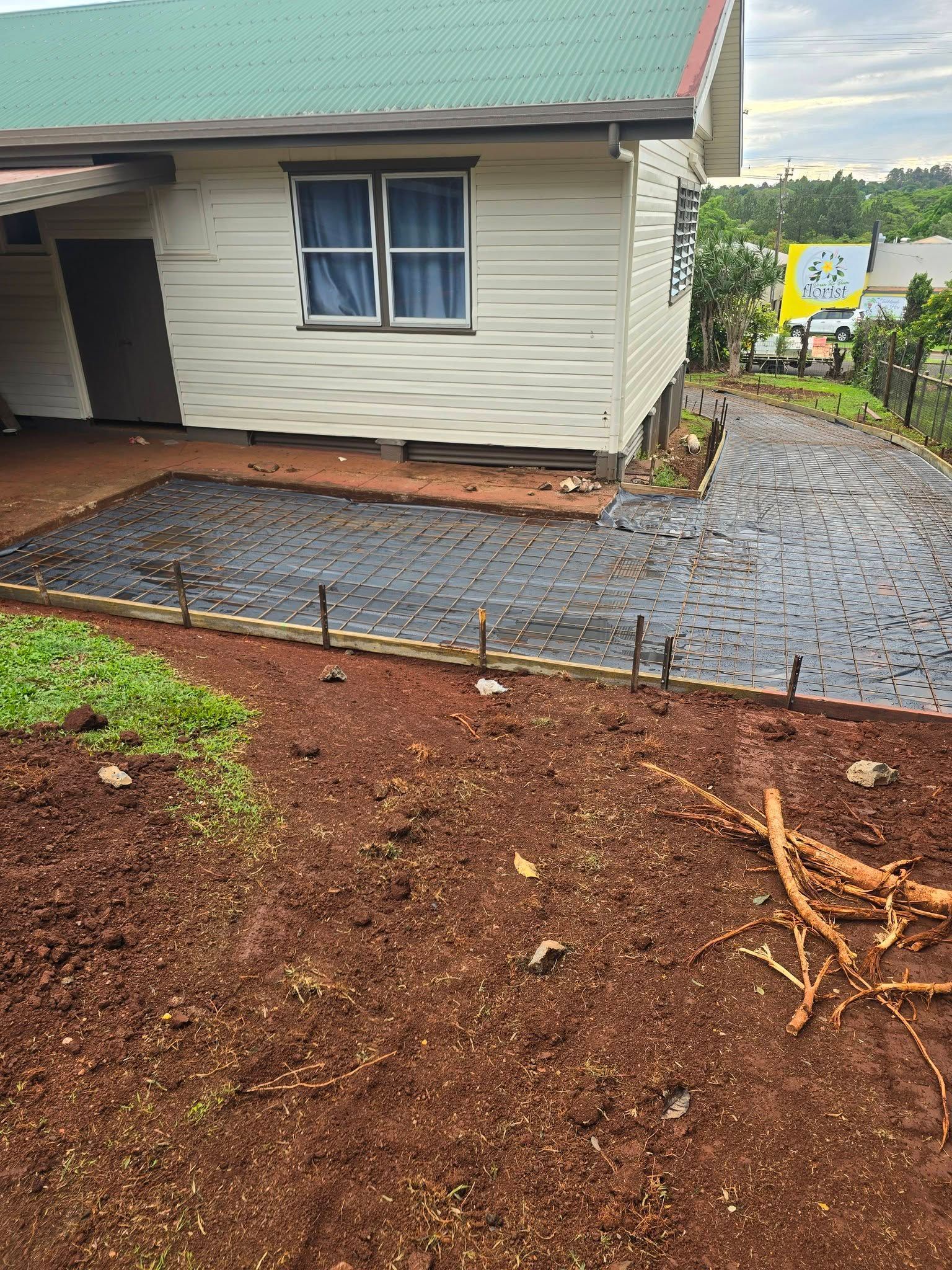 Driveway Being Constructed Next to a White House With a Green Roof — Sun Co Concrete And Construction in Dimbulah, QLD