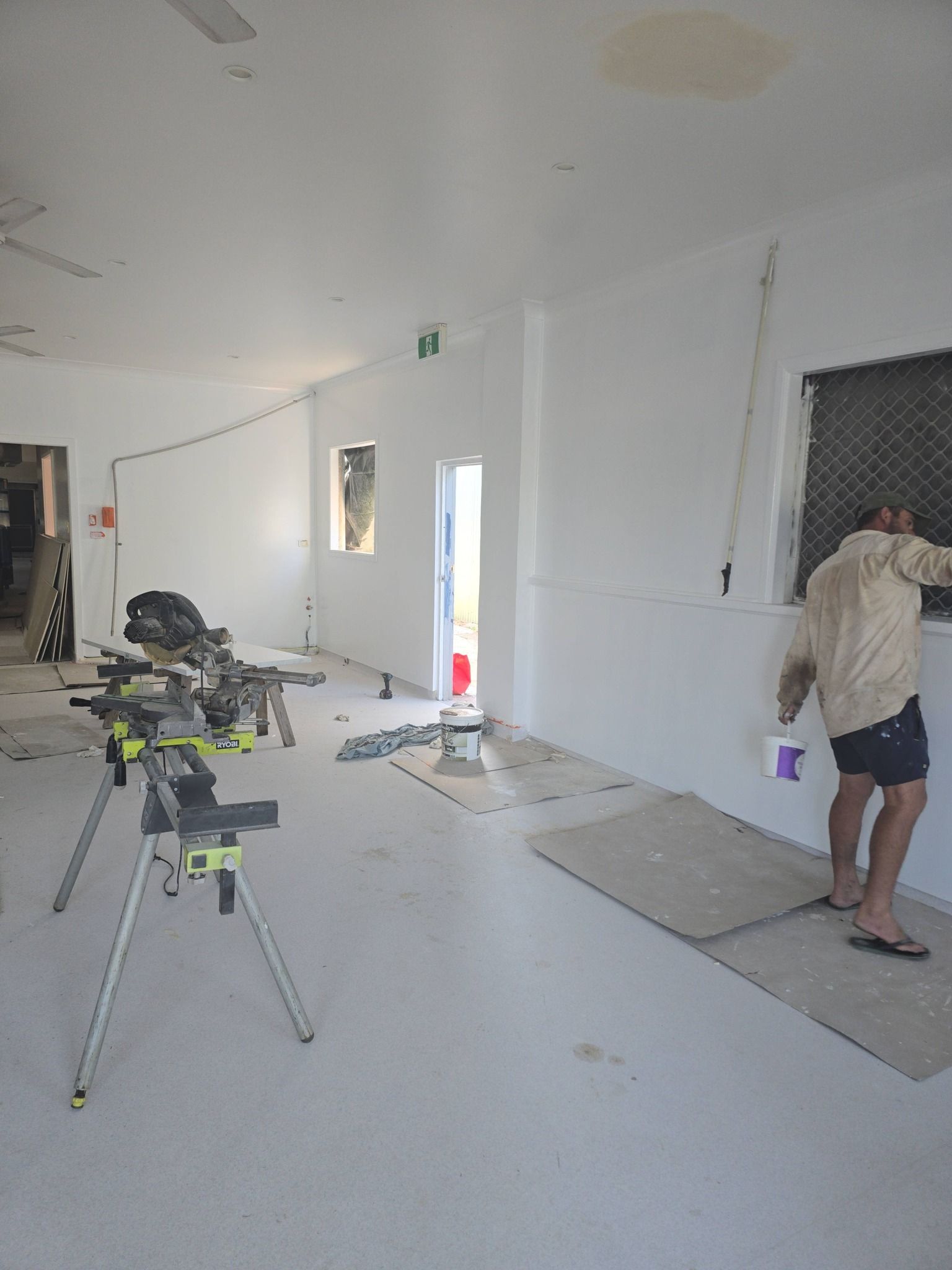 Man Painting Interior Wall Near Window — Sun Co Concrete And Construction in Dimbulah, QLD