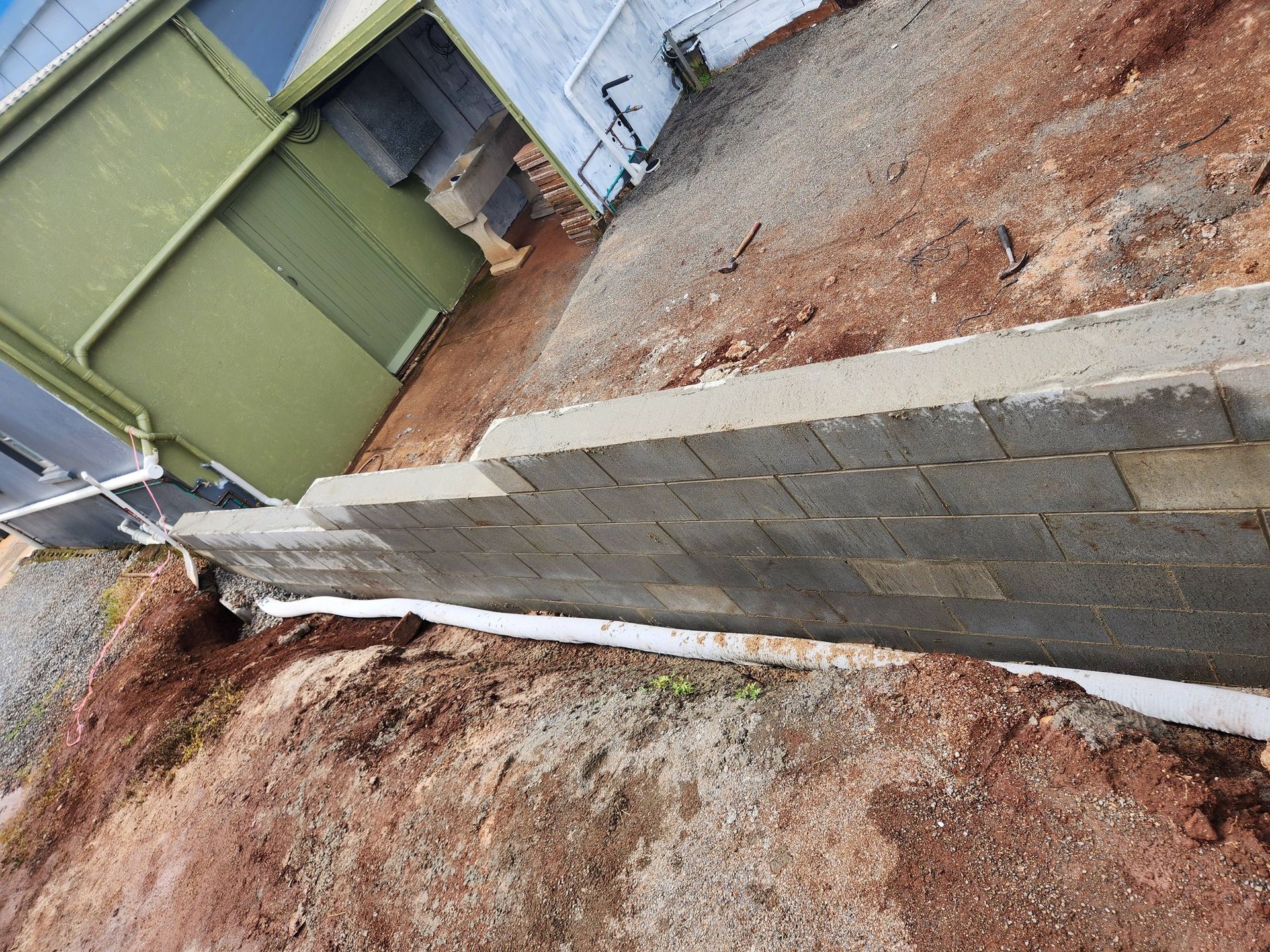 Retaining Wall Built of Gray Concrete Blocks Beside a Building — Sun Co Concrete And Construction in Dimbulah, QLD