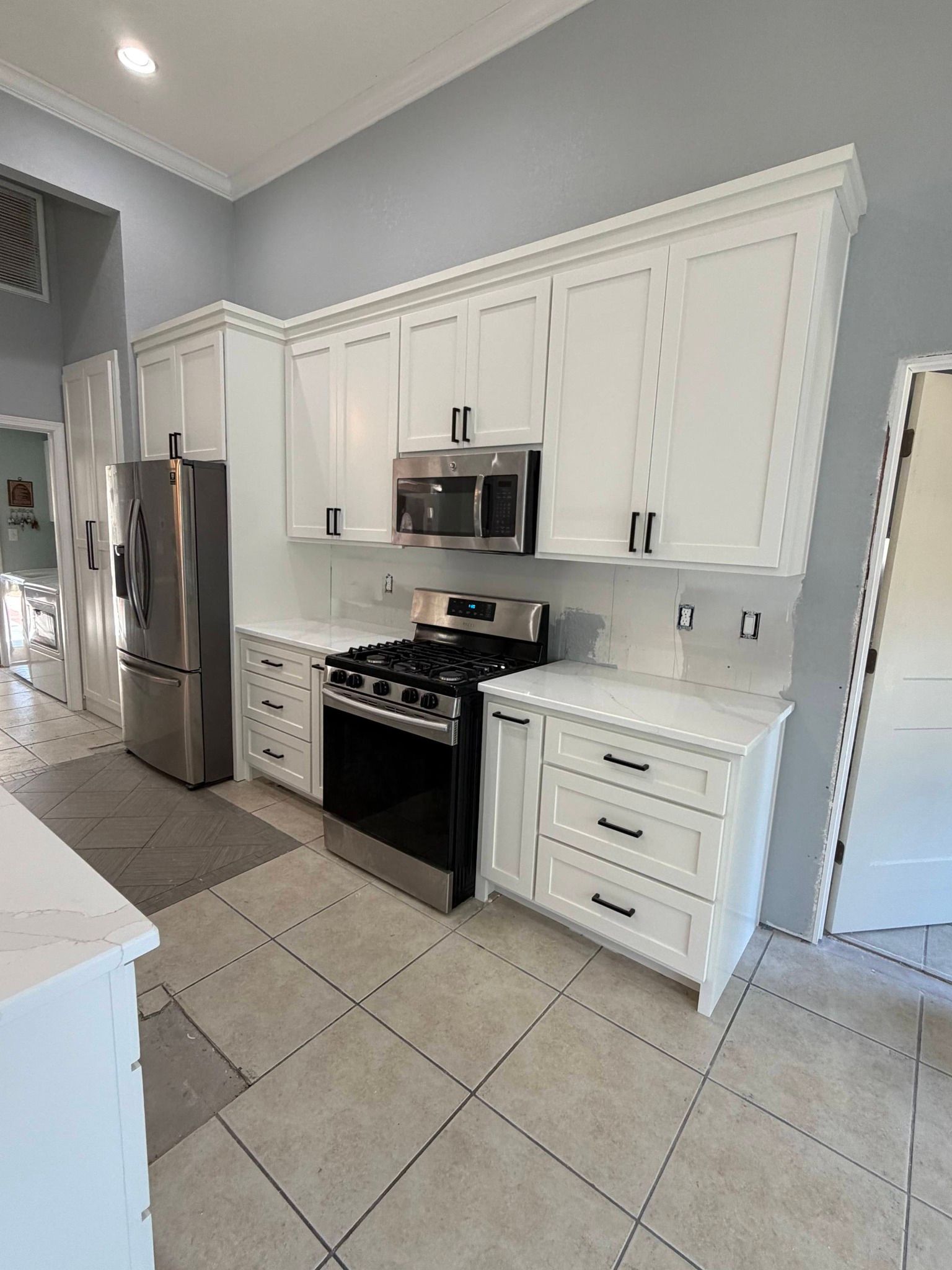 White wardrobe wall with a central open wooden niche, display shelves, and integrated drawers in a modern interior.