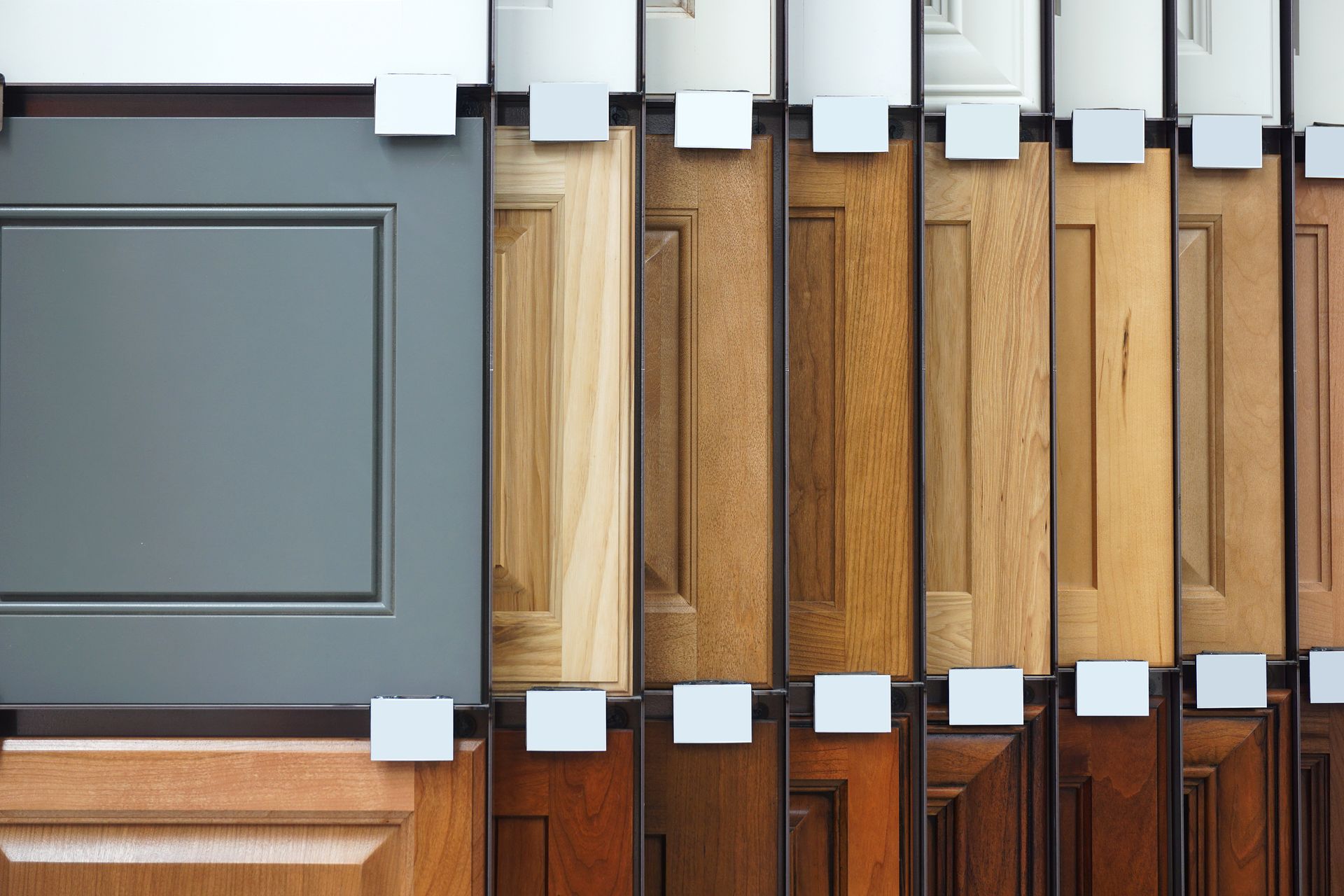 A display of various cabinet door samples featuring a wide range of wood grains, finishes, and colors.