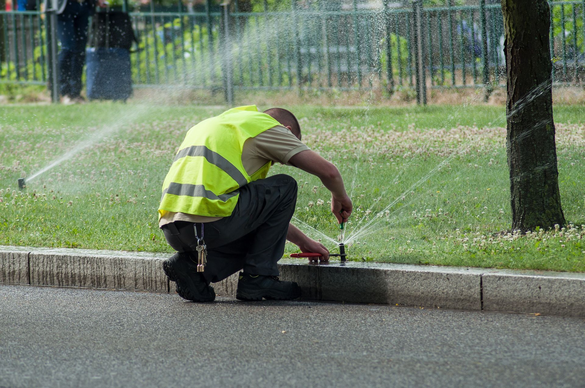 Transportation company employee adjusting automatic sprinklers.
