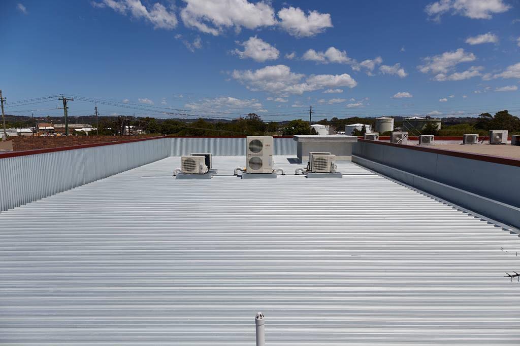 The roof of a building with a lot of air conditioners on it.