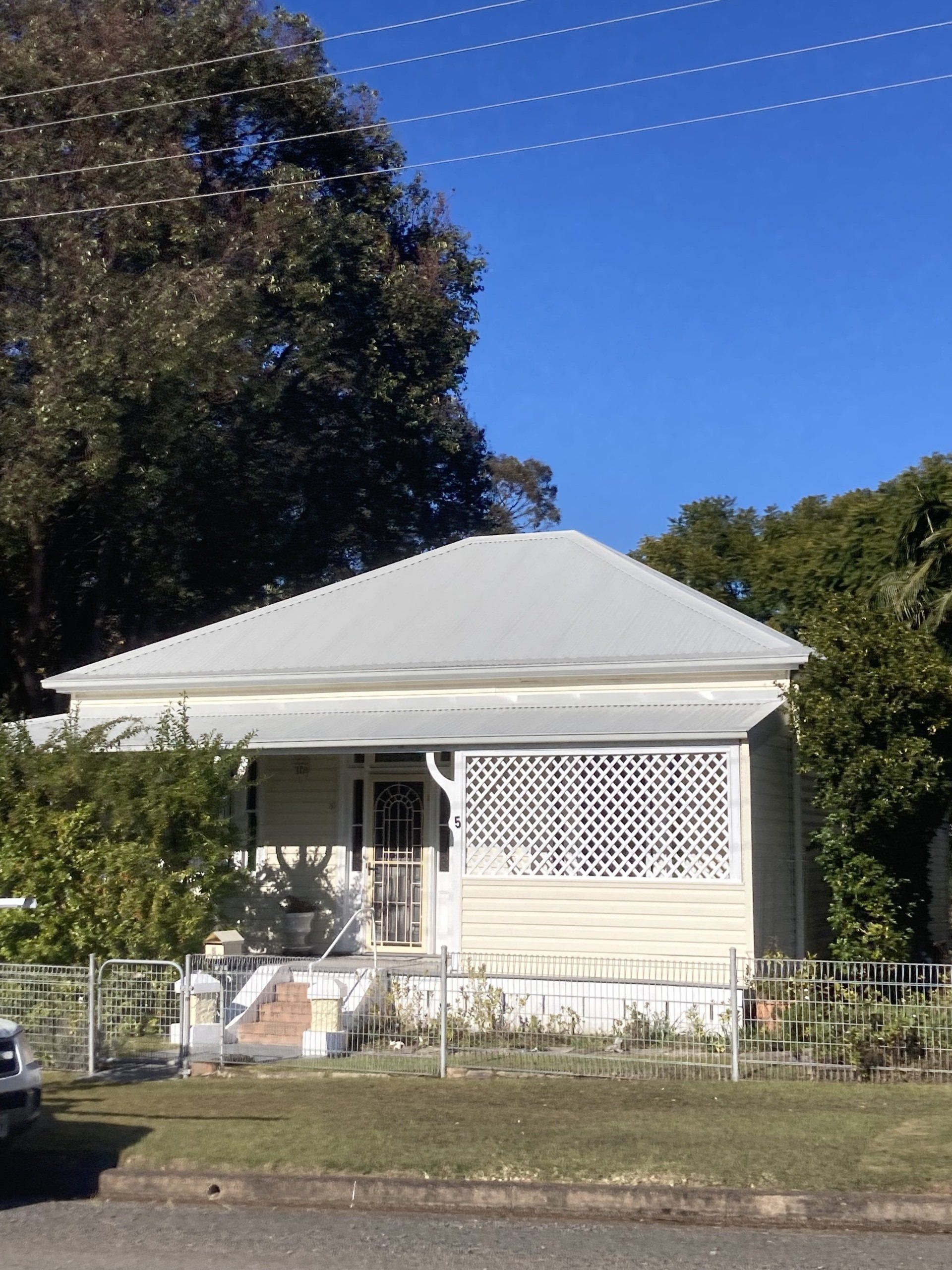A white house with a white roof is surrounded by trees