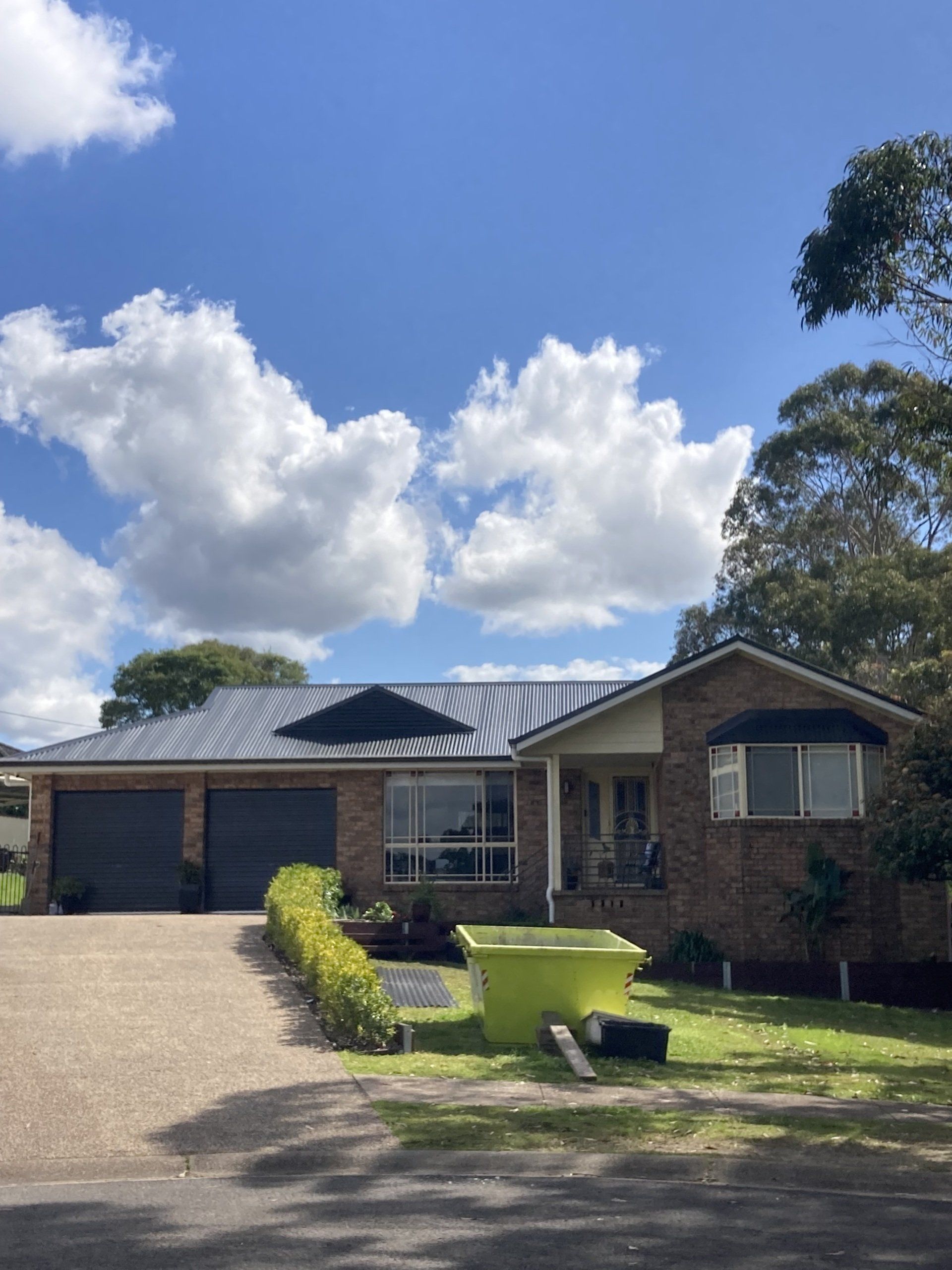 A house with a blue sky and clouds in the background