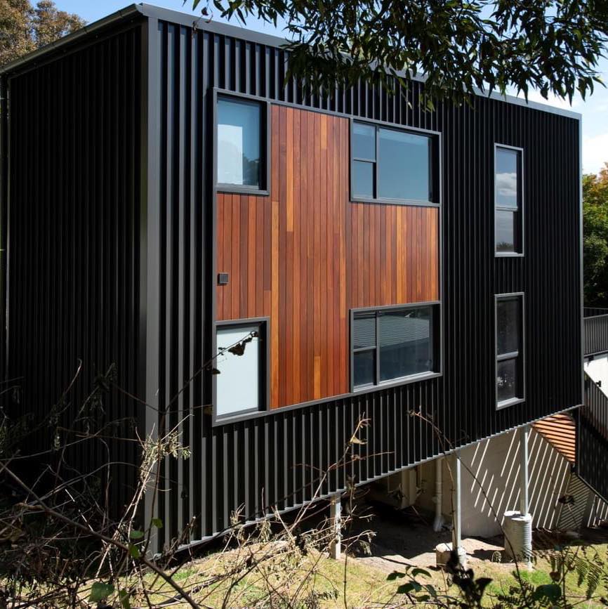 A house with a black siding and wood paneling