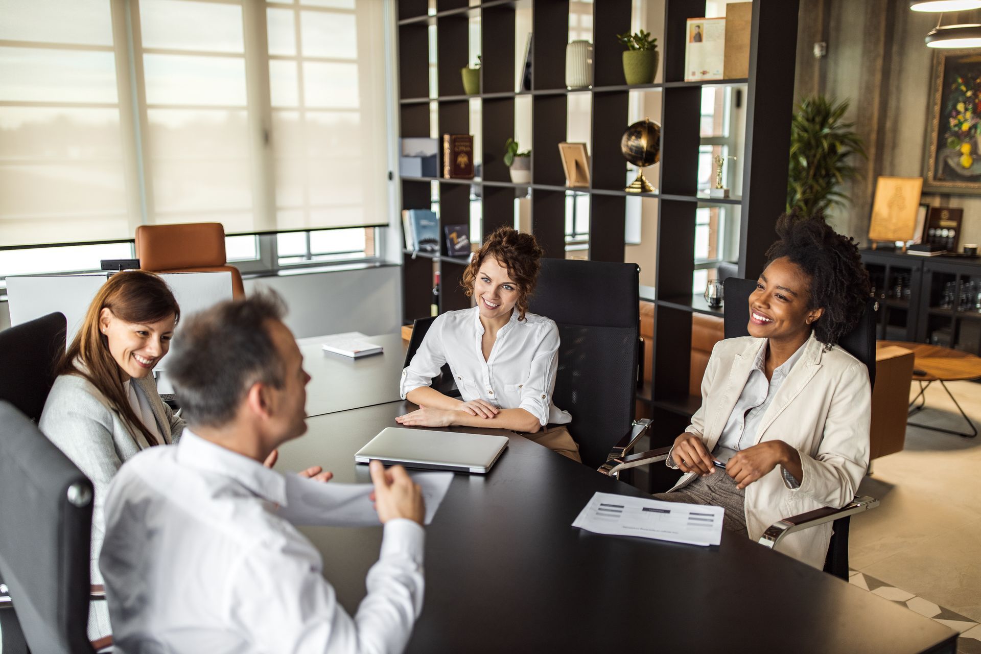 A group of people are sitting around a table having a meeting.