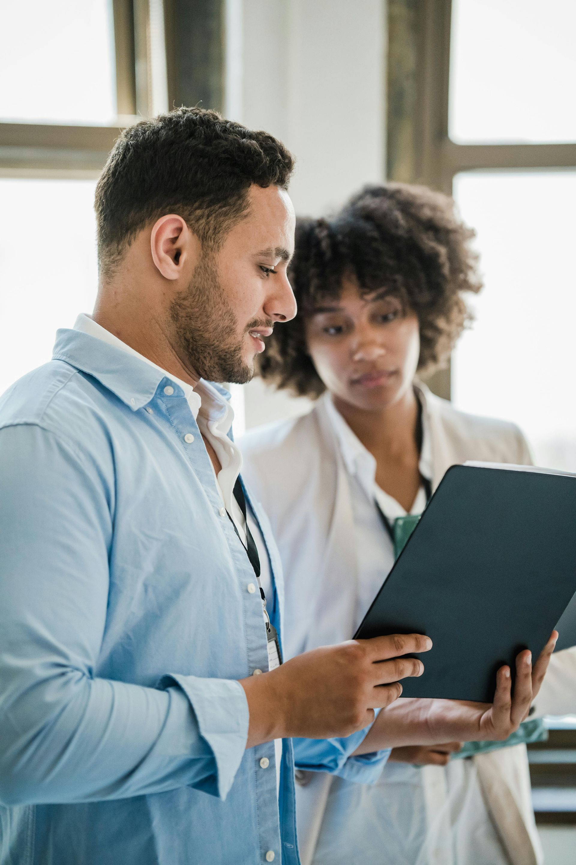 A man and a woman are looking at a clipboard.