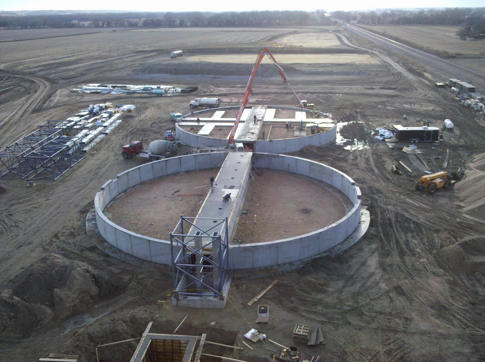 An aerial view of a construction site with a large circular structure in the middle