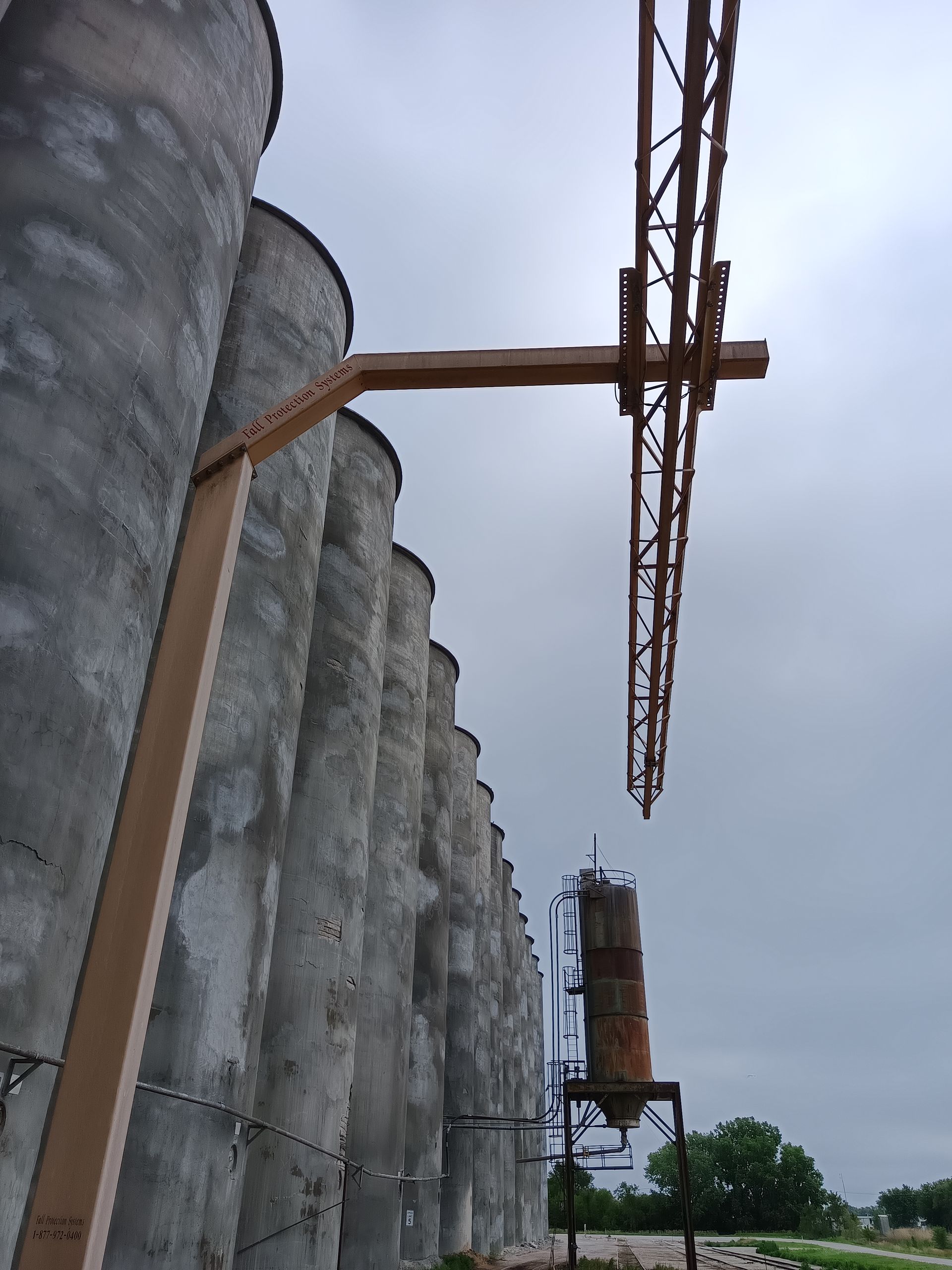 A row of silos are lined up against a cloudy sky