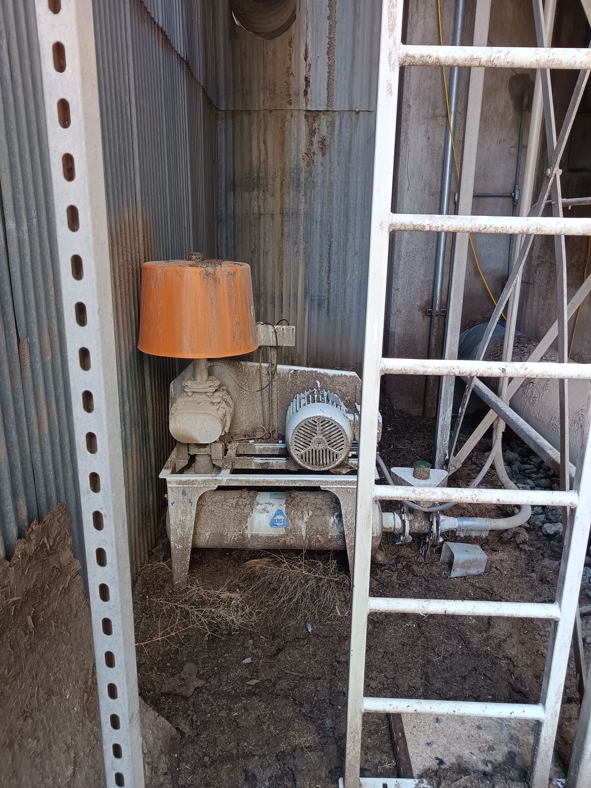 A lamp is sitting on a table in a dirty room next to a ladder.