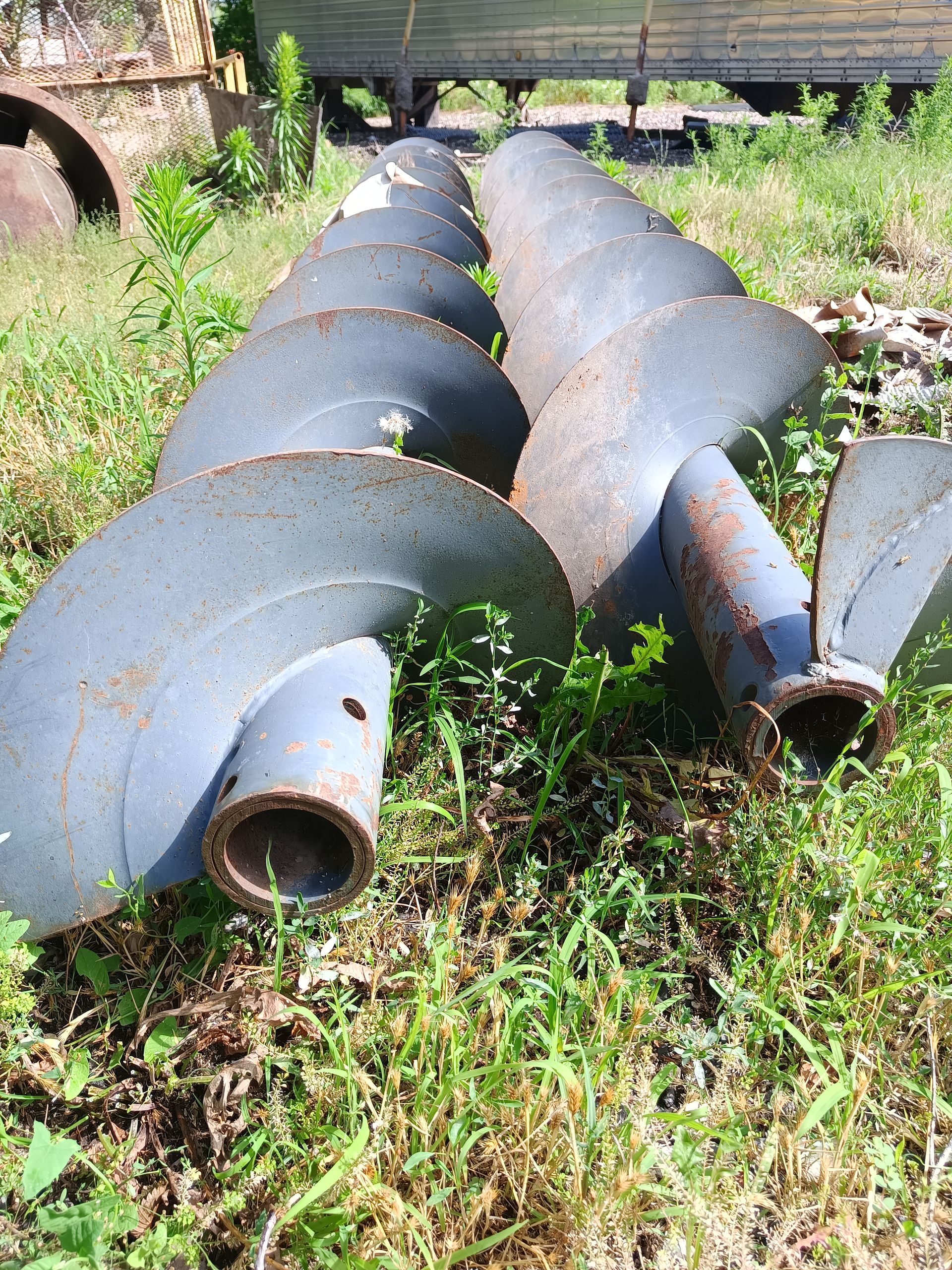 A bunch of metal screws are sitting in the grass