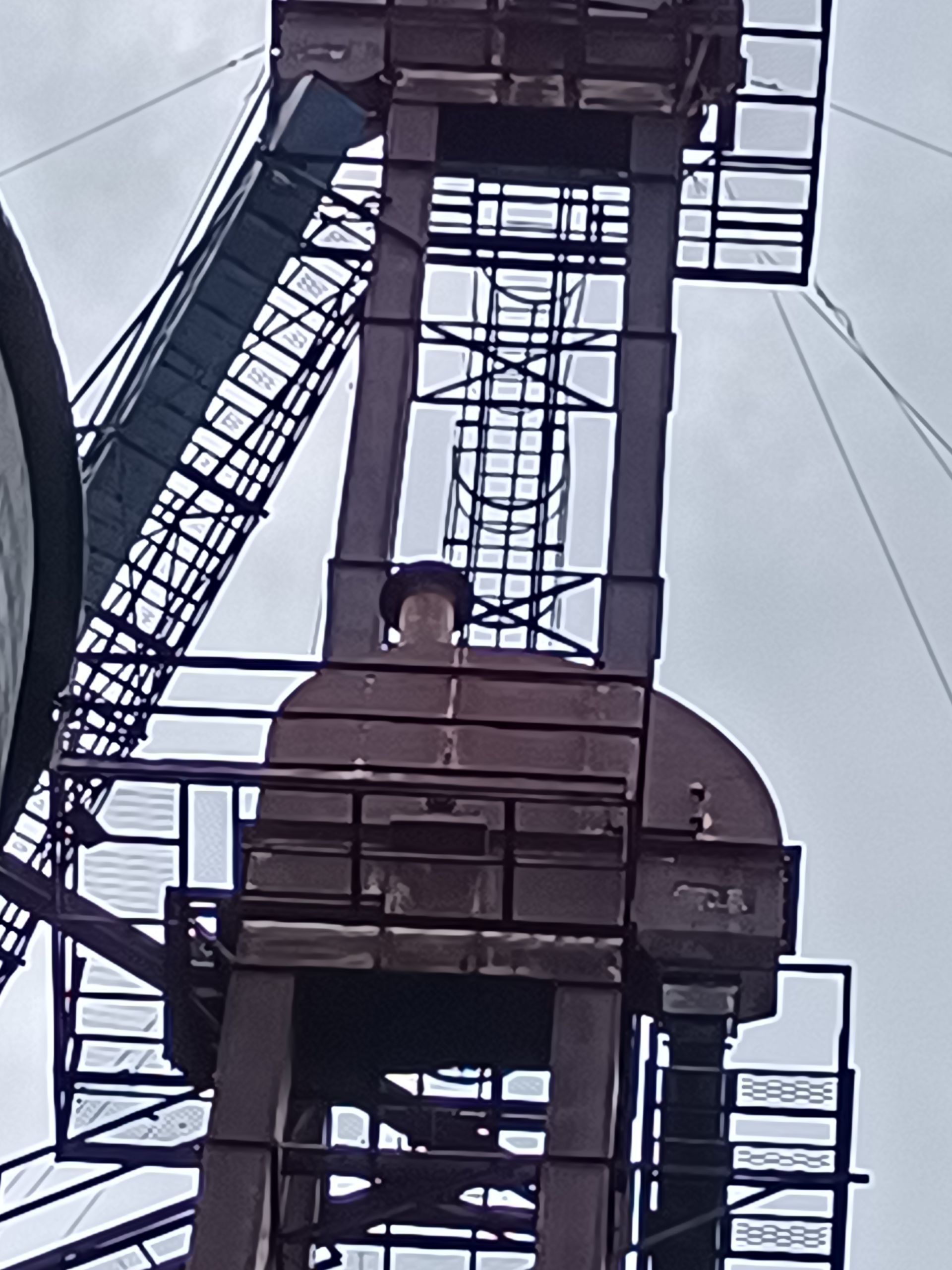 A man in a hat stands on top of a very tall building