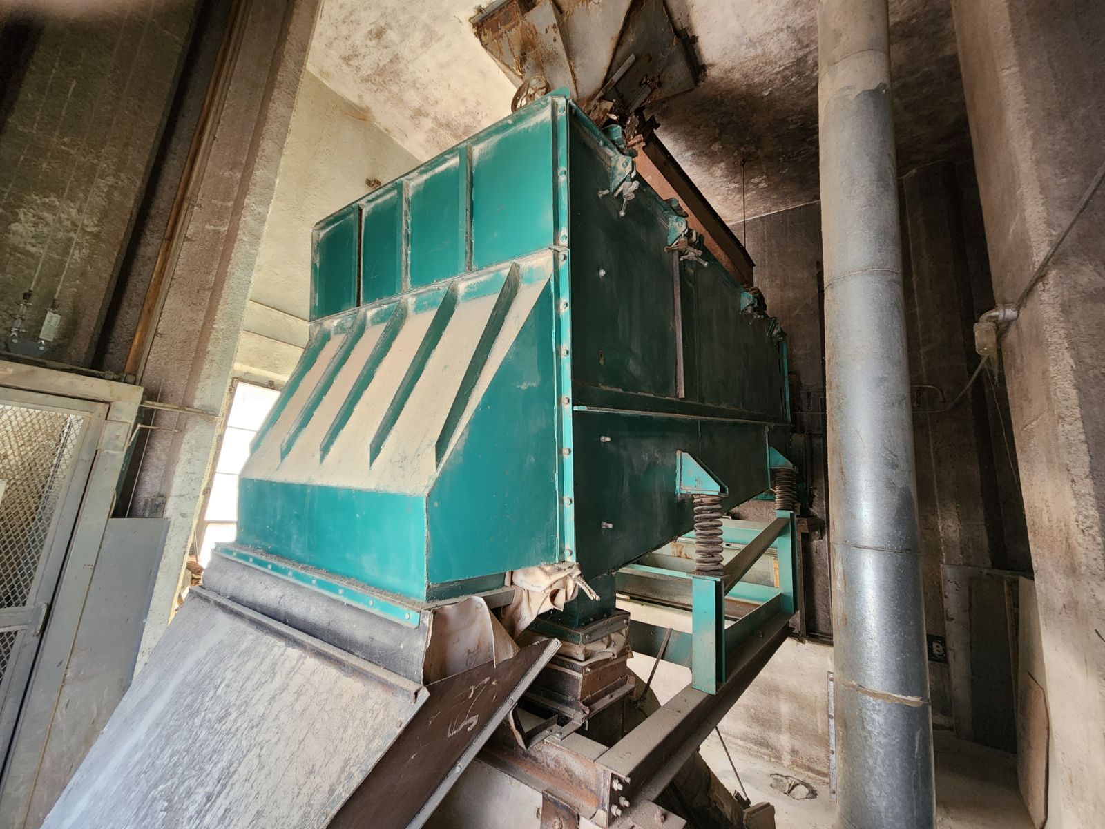 A large green machine is sitting inside of a building.