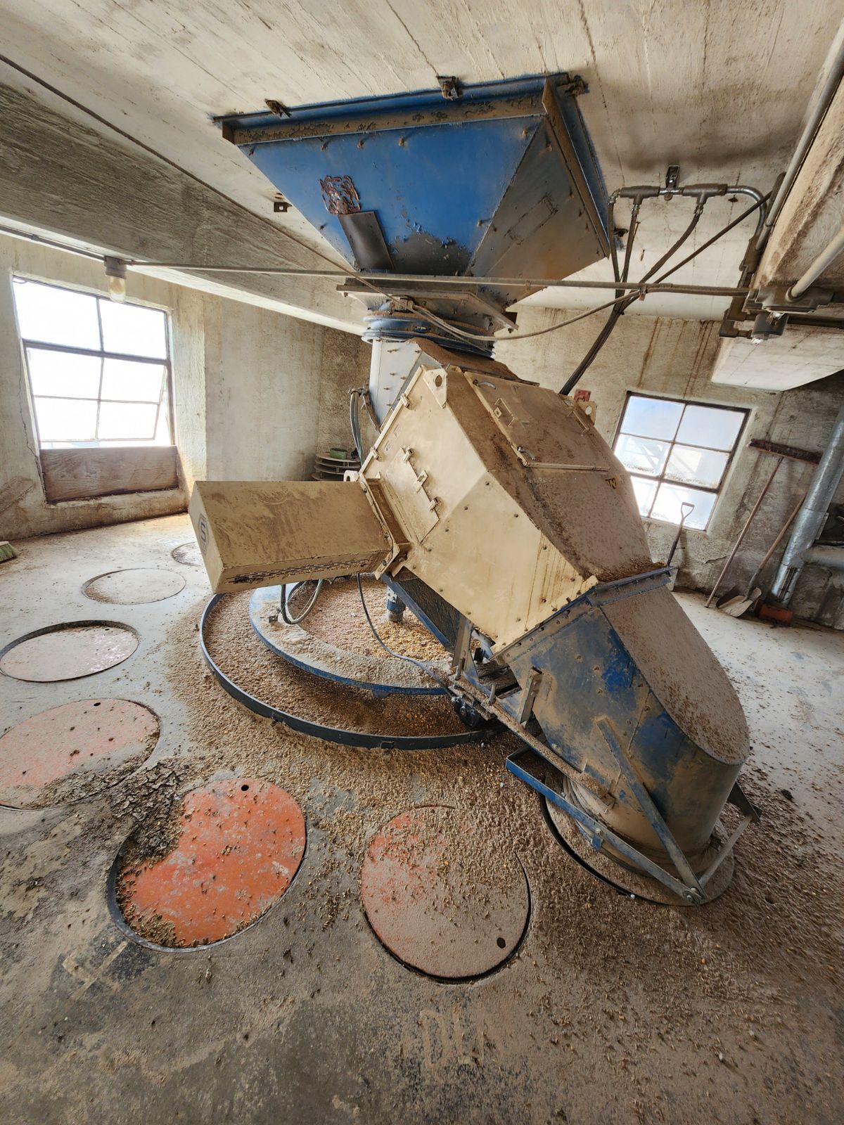A machine is sitting in the middle of a room in a factory.