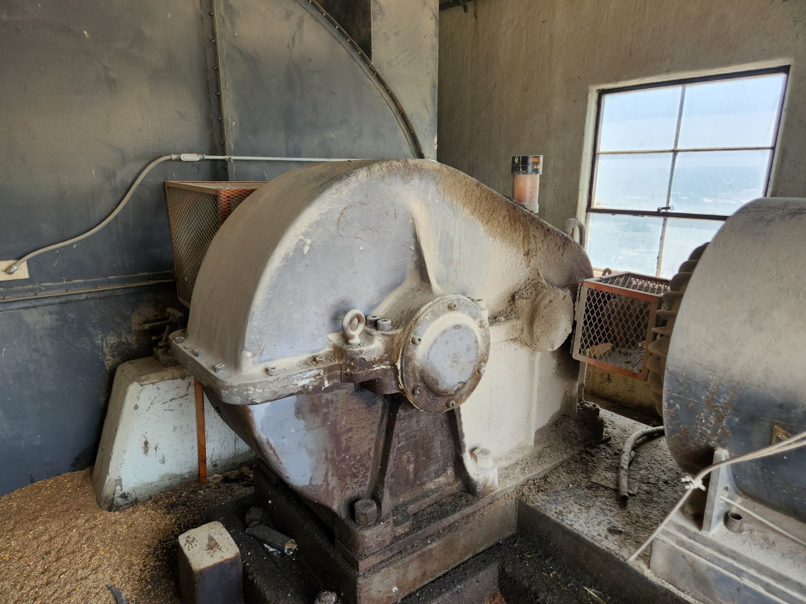 A large machine is sitting in a room next to a window.