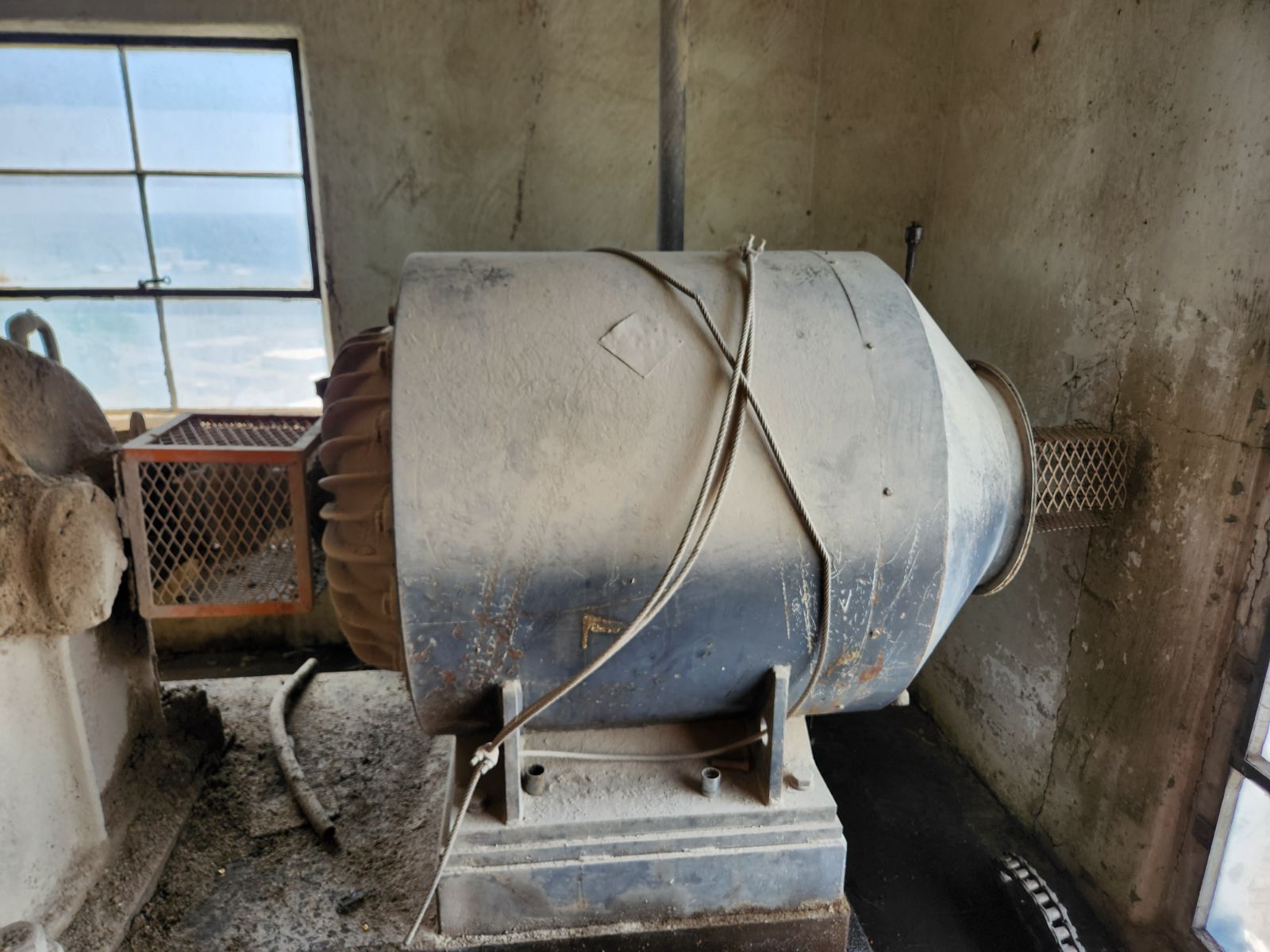 A large dirty machine is in a room next to a window