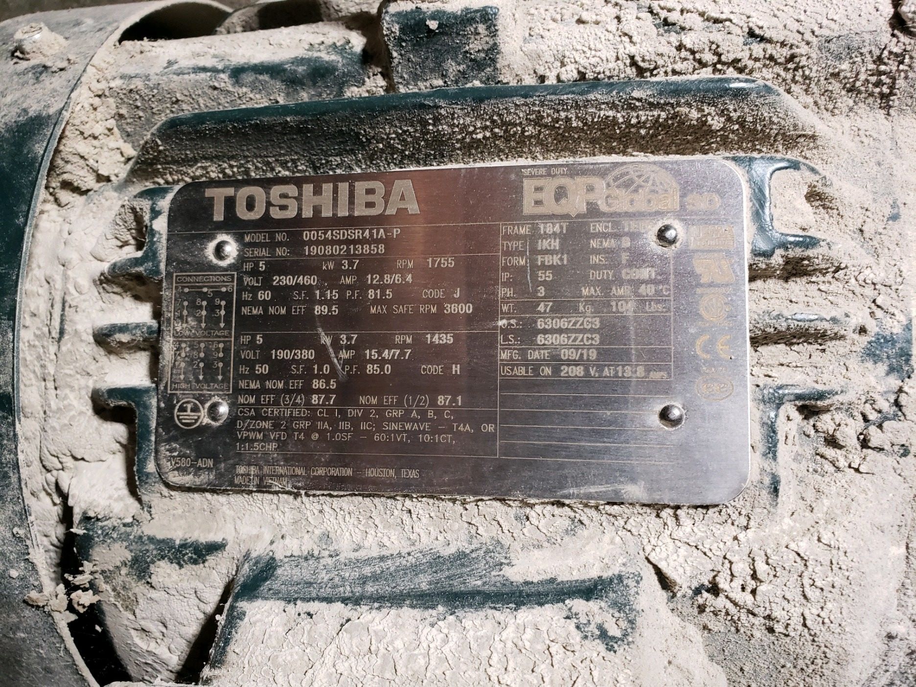 A toshiba motor is covered in dust and dirt