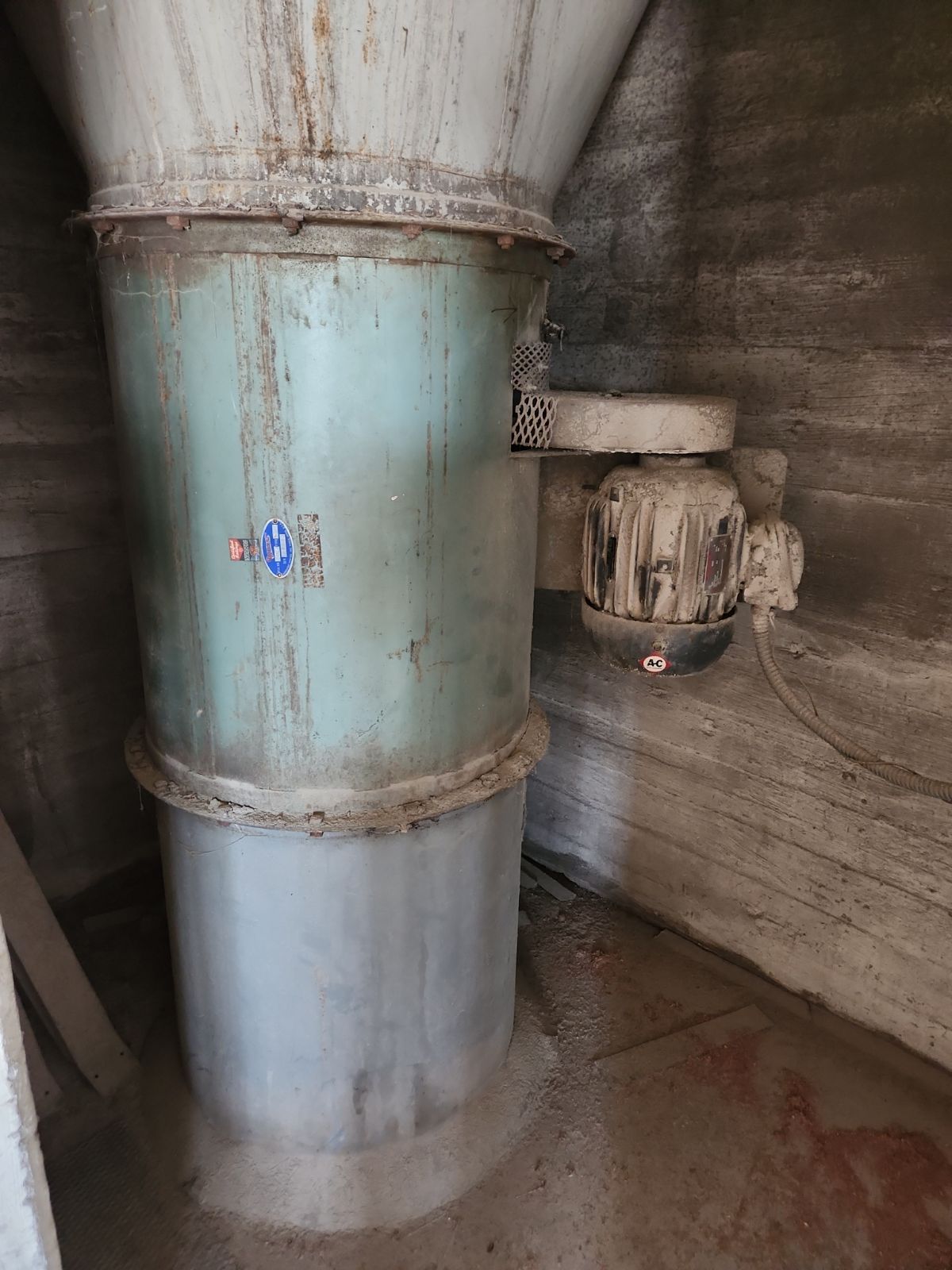 A large metal pipe is sitting in a room next to a wall.