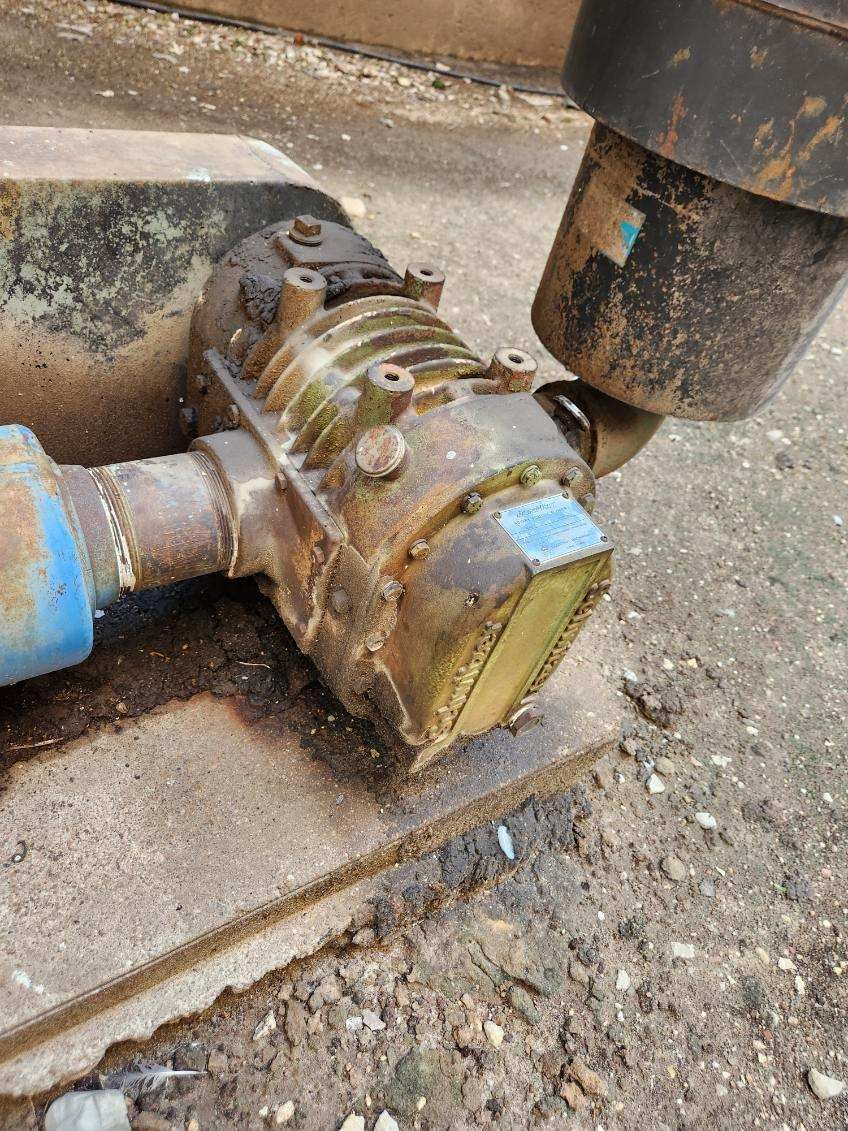 A close up of a rusty piece of equipment on the ground.