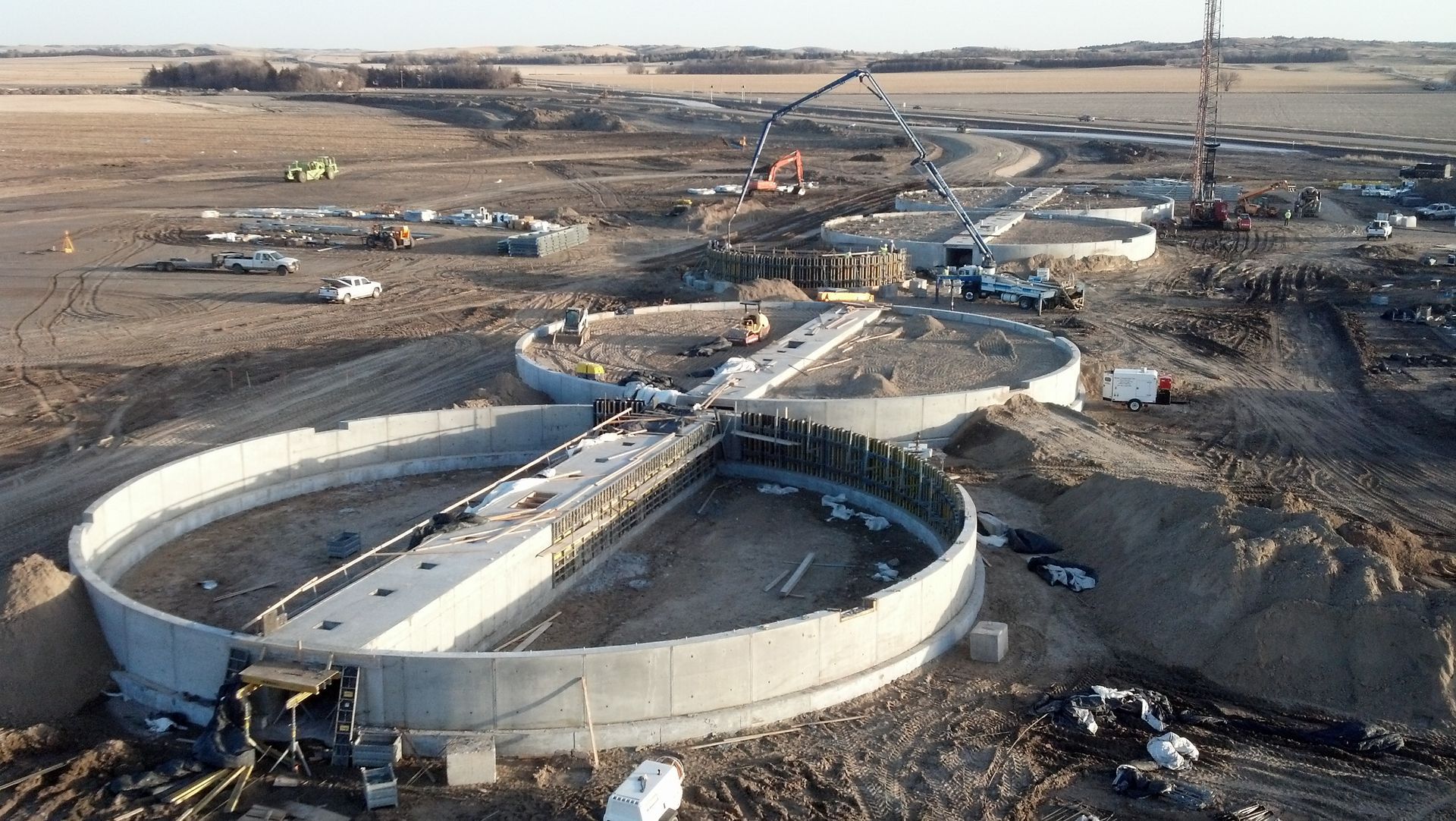 A large concrete structure is being built in the middle of a dirt field.