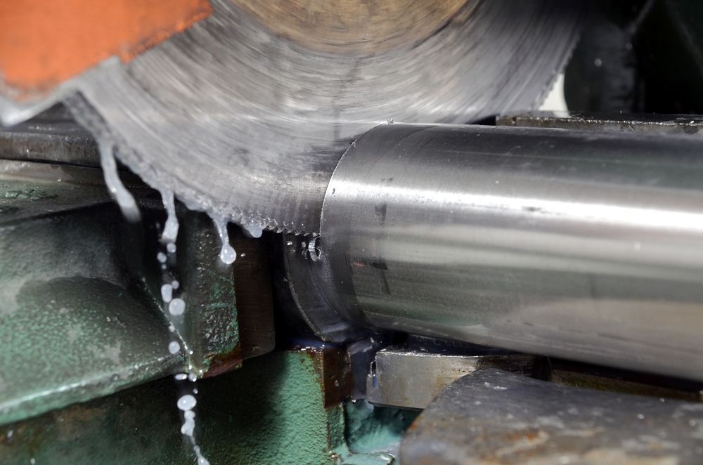 A Person is Cutting a Metal Pipe With a Circular Saw — Sun City Sheetmetal In Ayr, QLD