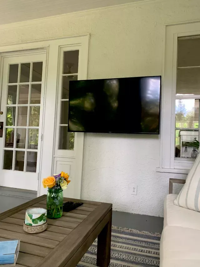 a living room with a newly installed flat screen tv mounted on the wall .