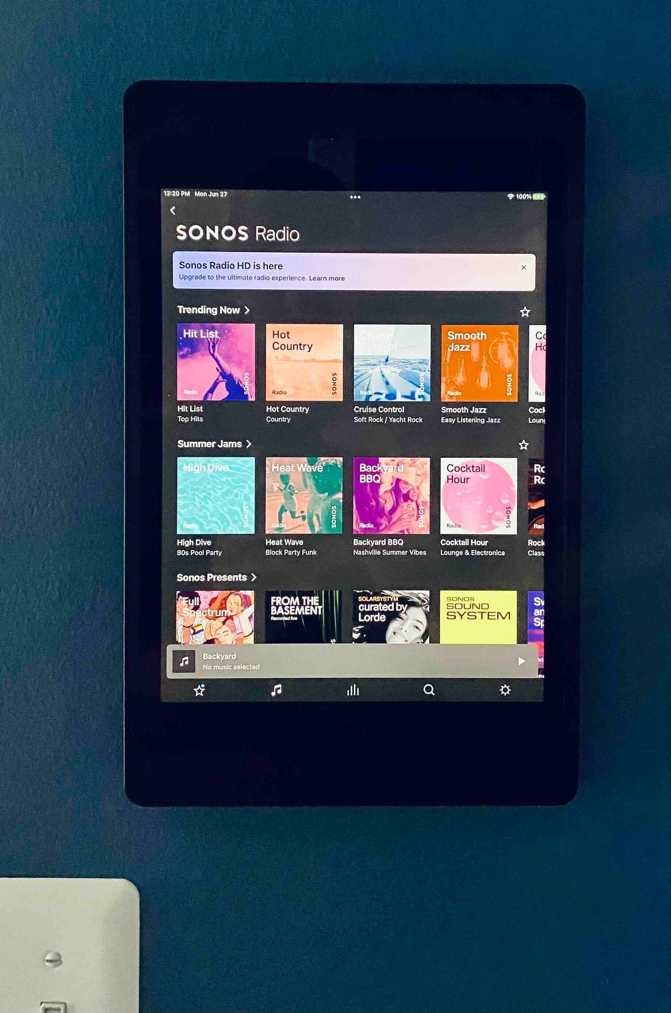 a newly installed tablet in wall with songs radio on the screen
