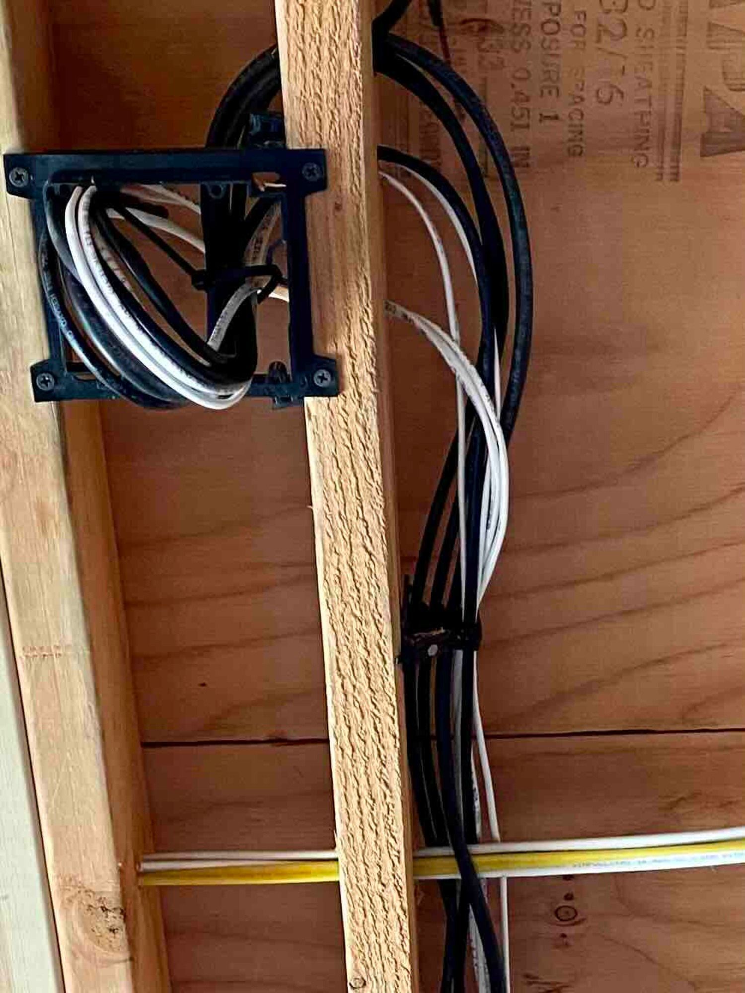 a bunch of wires are hanging from the ceiling in a wooden box for networking
