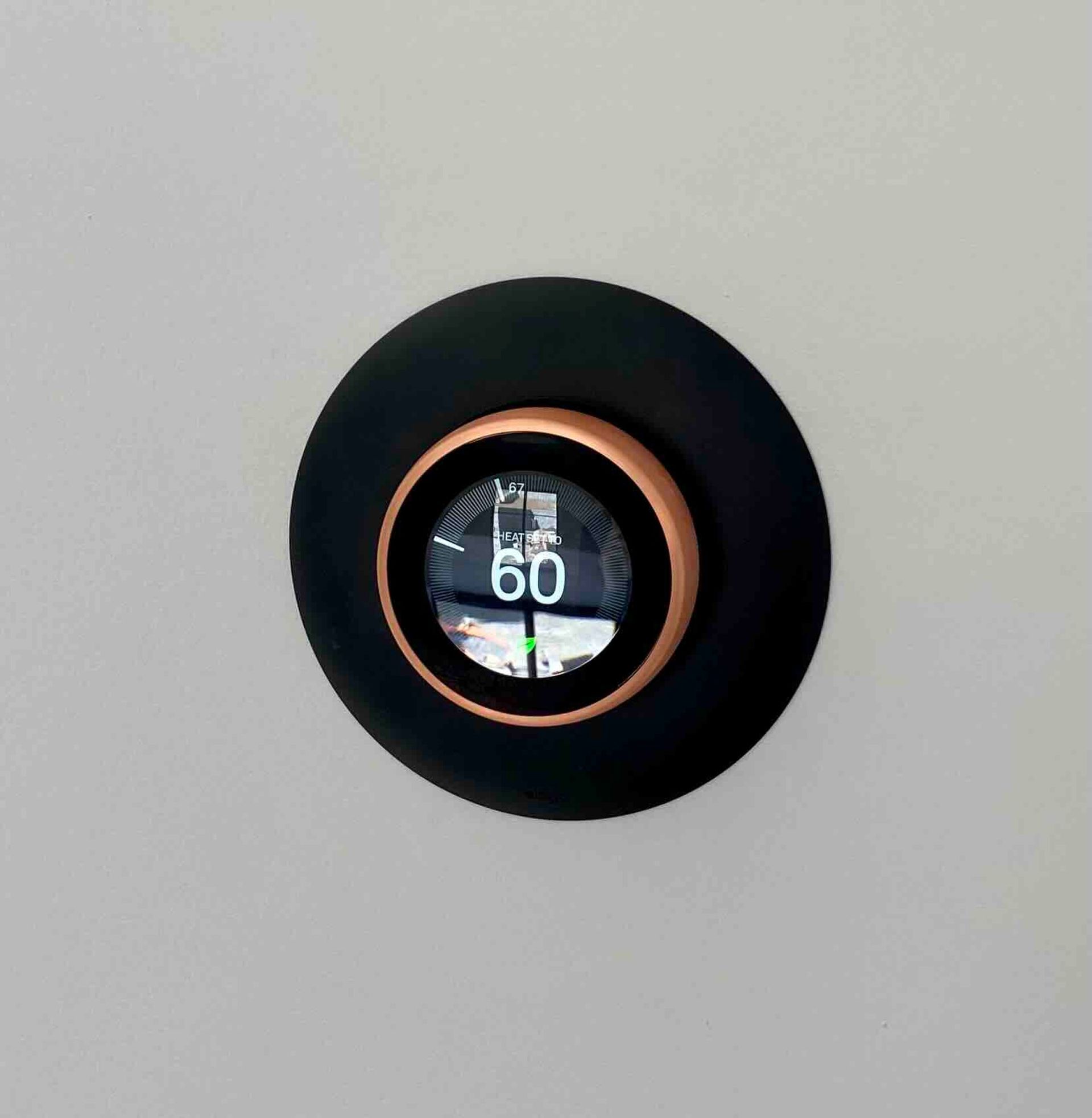 a black and copper newly installed thermostat with the number 60 on it