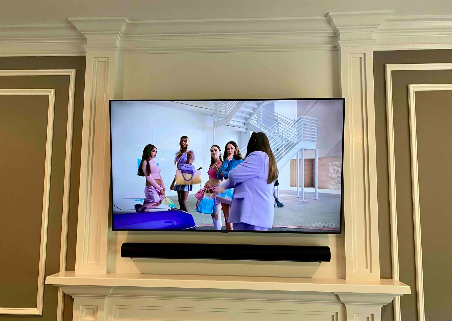a newly installed flat screen tv is hanging on a wall above a fireplace .