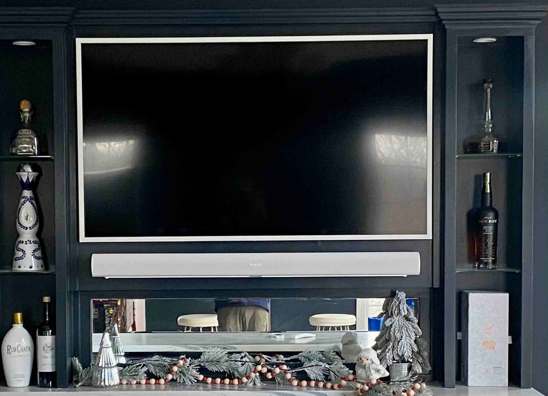 a newly installed large flat screen tv is mounted on a wall above a fireplace .