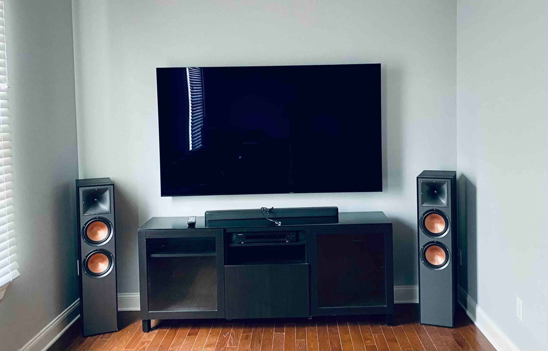 a living room with a newly installed flat screen tv and speakers .