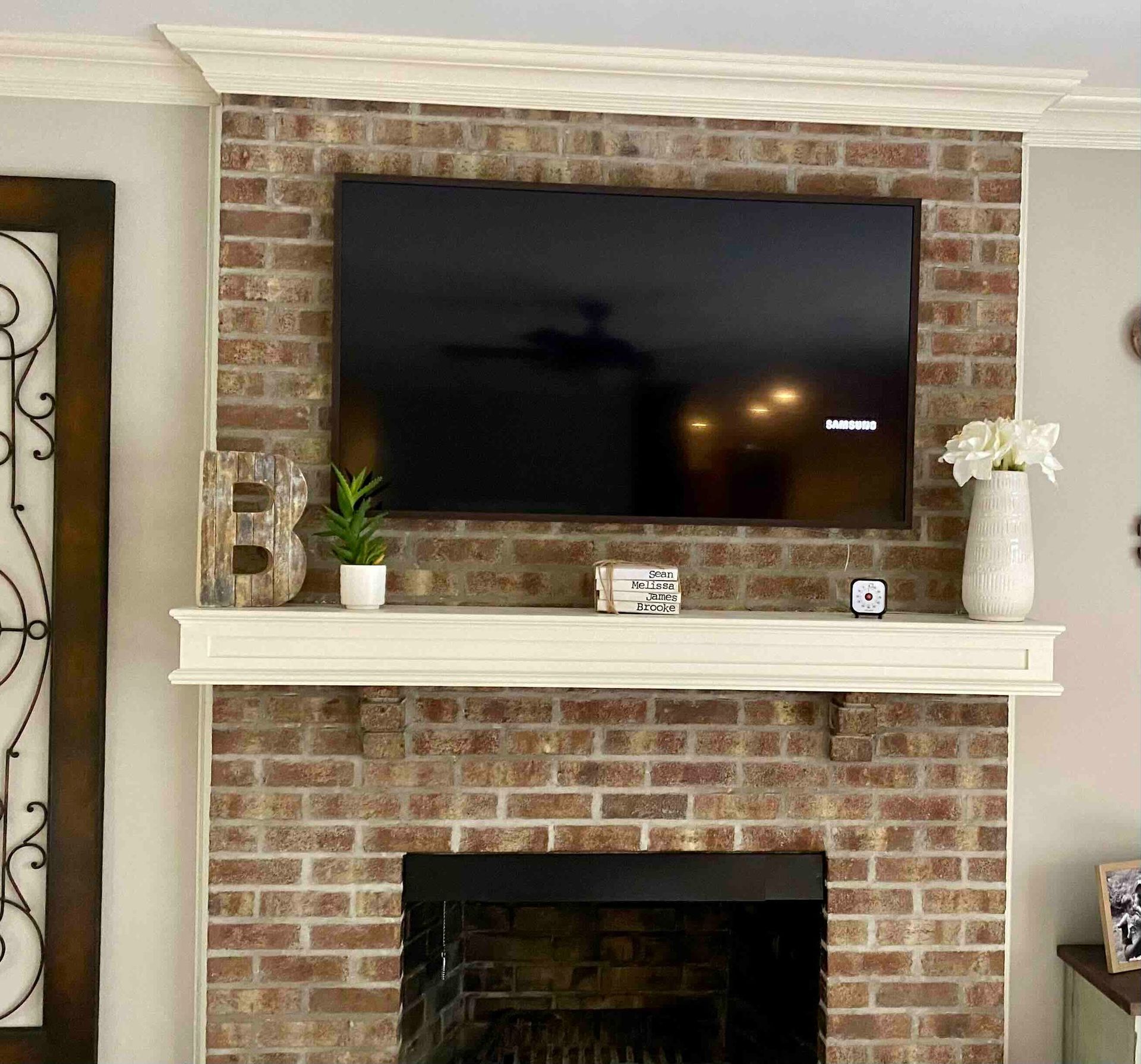 a living room with a fireplace and a newly installed flat screen tv above it .