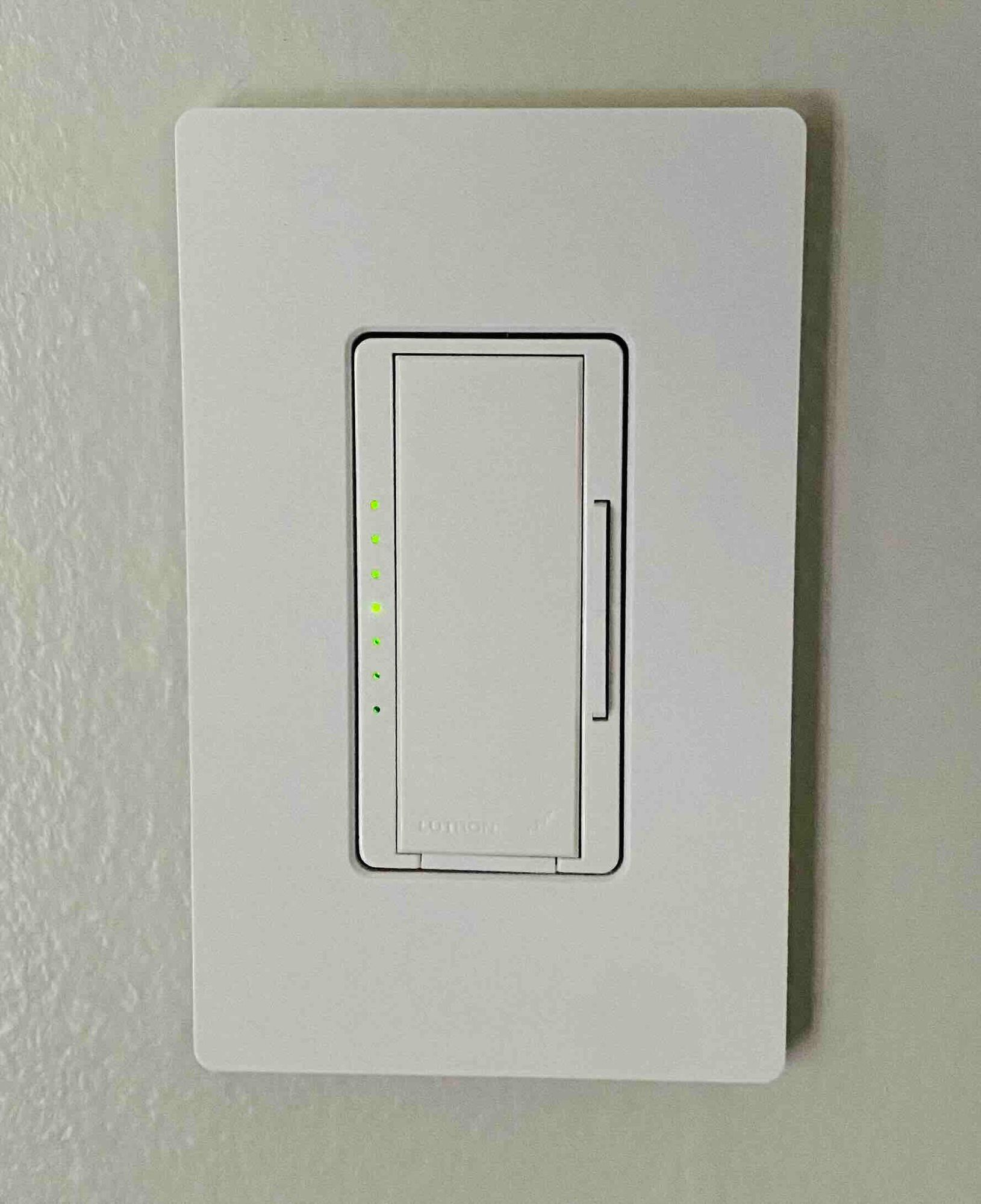 a white light switch is mounted on a white wall