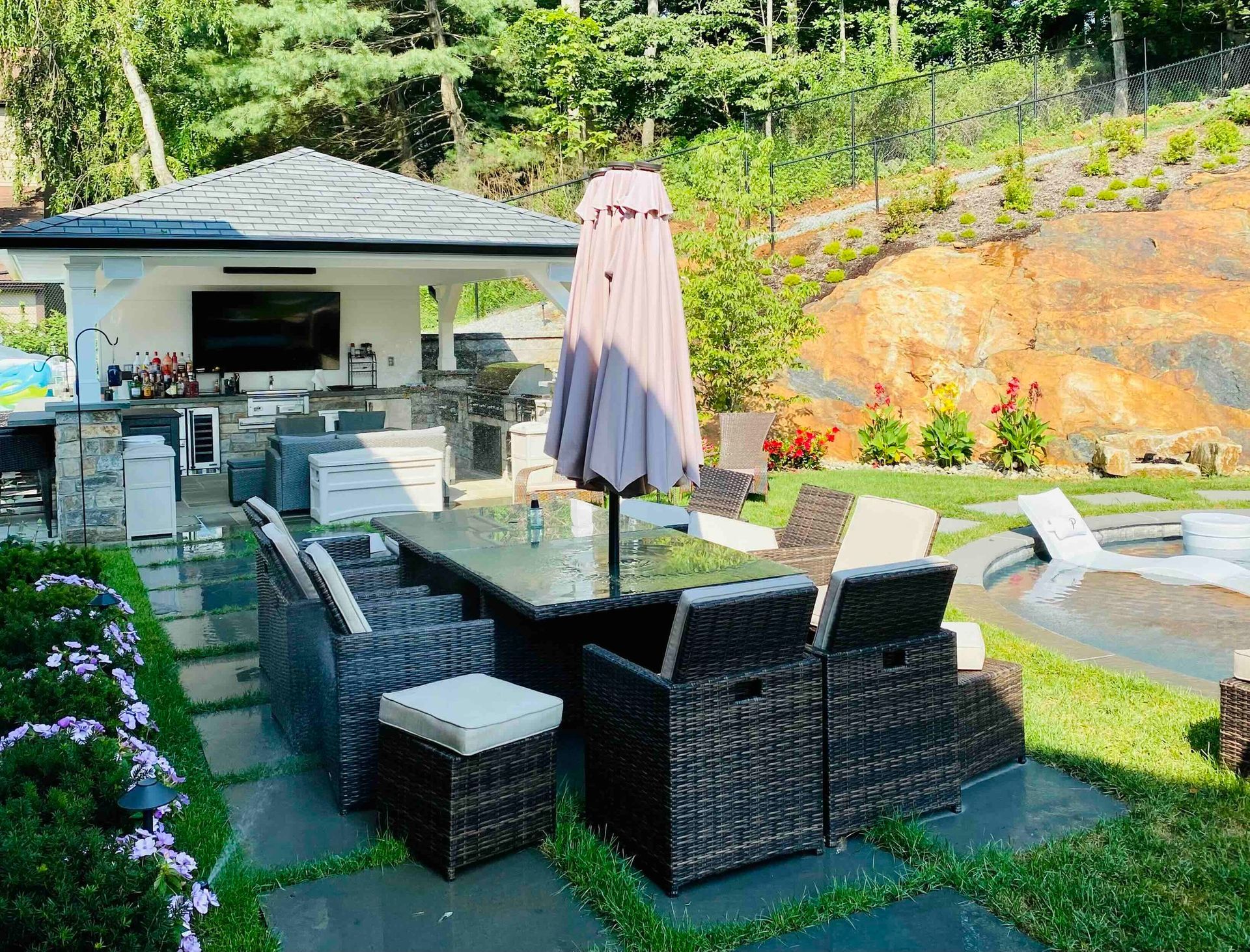 a patio area with a table and chairs and an umbrella with the newly installed TV