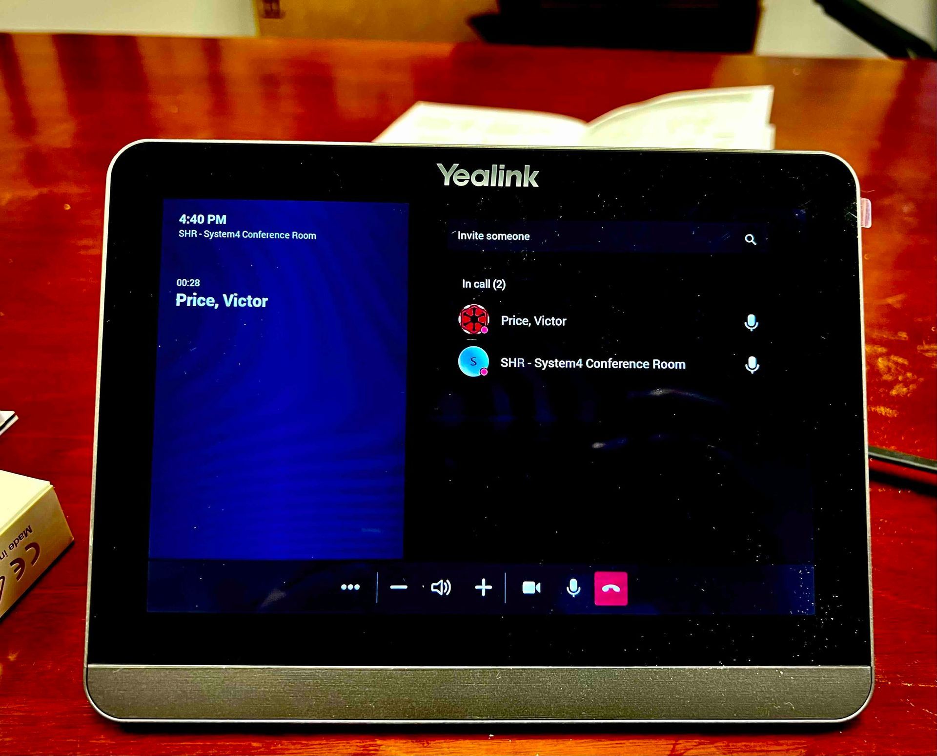 a newly installed yealink device sits on a wooden table for the conference room