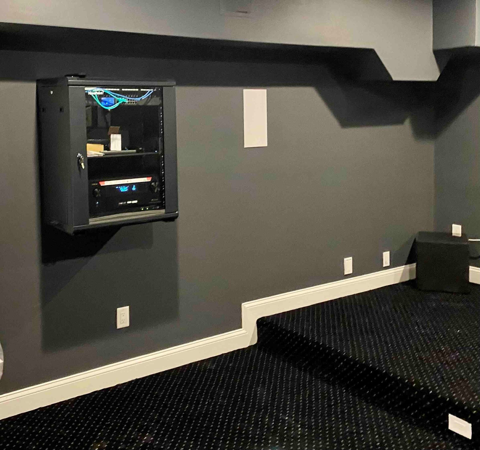 a room with a black carpet and a wall mounted cabinet