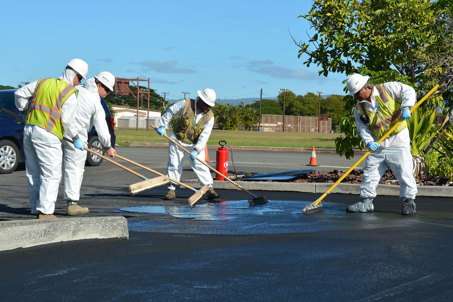 A group of construction workers are working on a parking lot