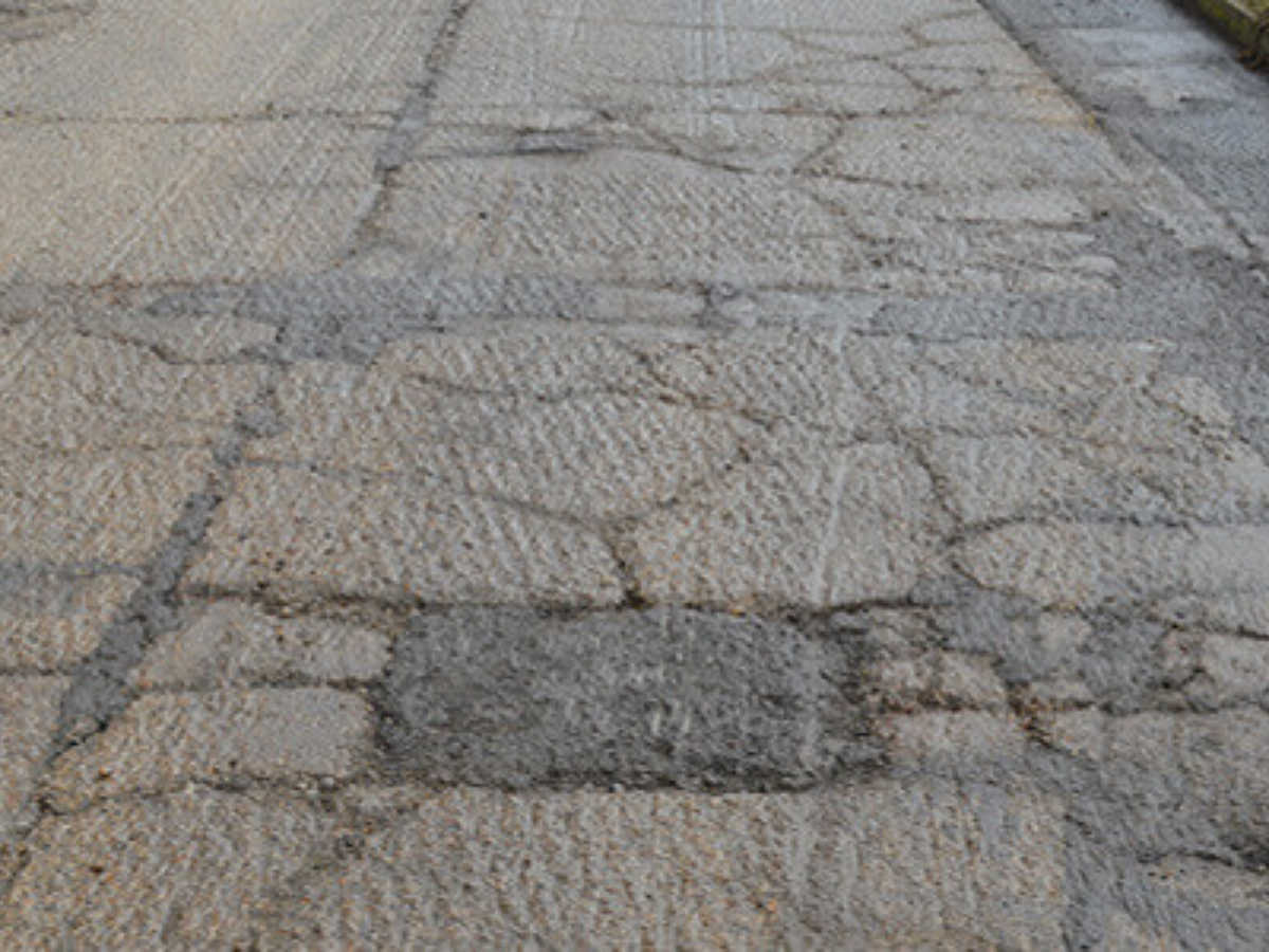 A close up of a pavement with a lot of cracks in it.