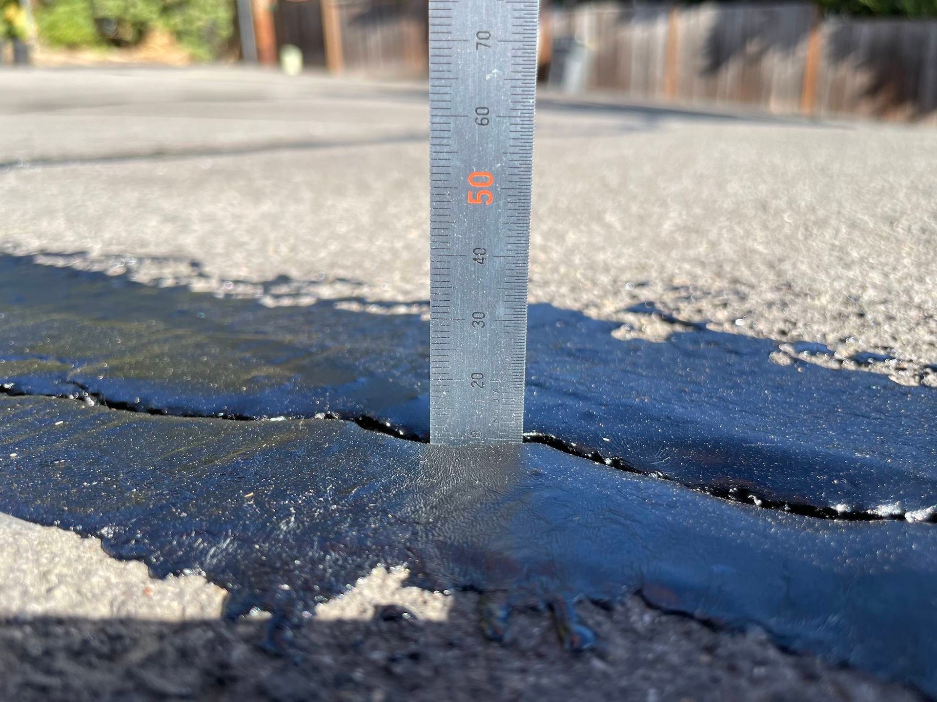 A ruler being used to check asphalt.