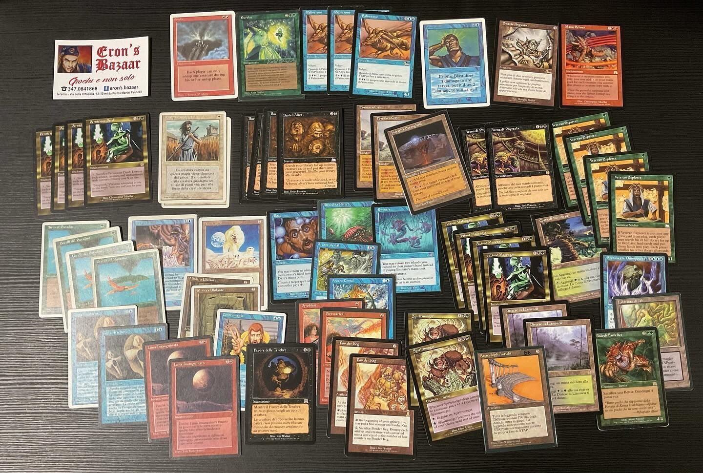 Una vasta collezione di carte collezionabili vintage di Magic: The Gathering è distribuita su un tavolo di legno scuro.