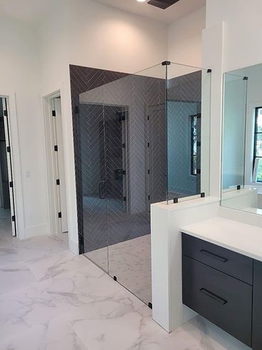A bathroom with a walk in shower and a large mirror.