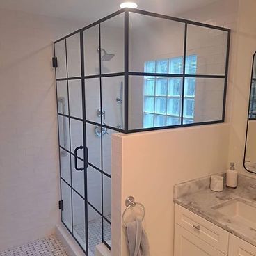 A bathroom with a walk in shower and a sink.