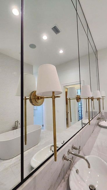 A bathroom with two sinks , a bathtub , and a large mirror.