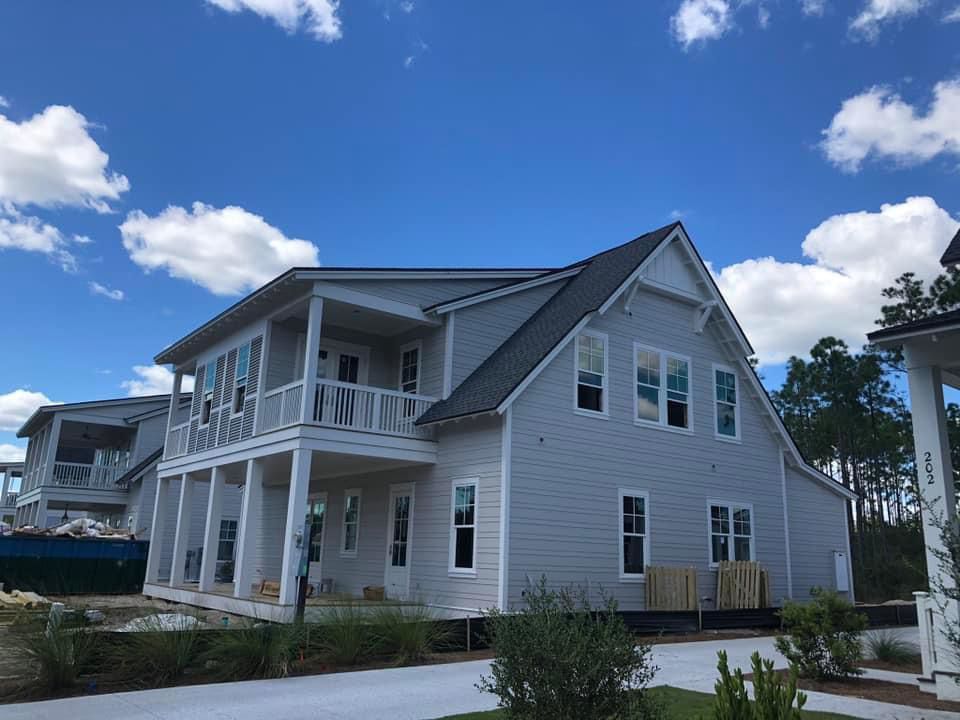 A kitchen with white cabinets , stainless steel appliances , and a large island.